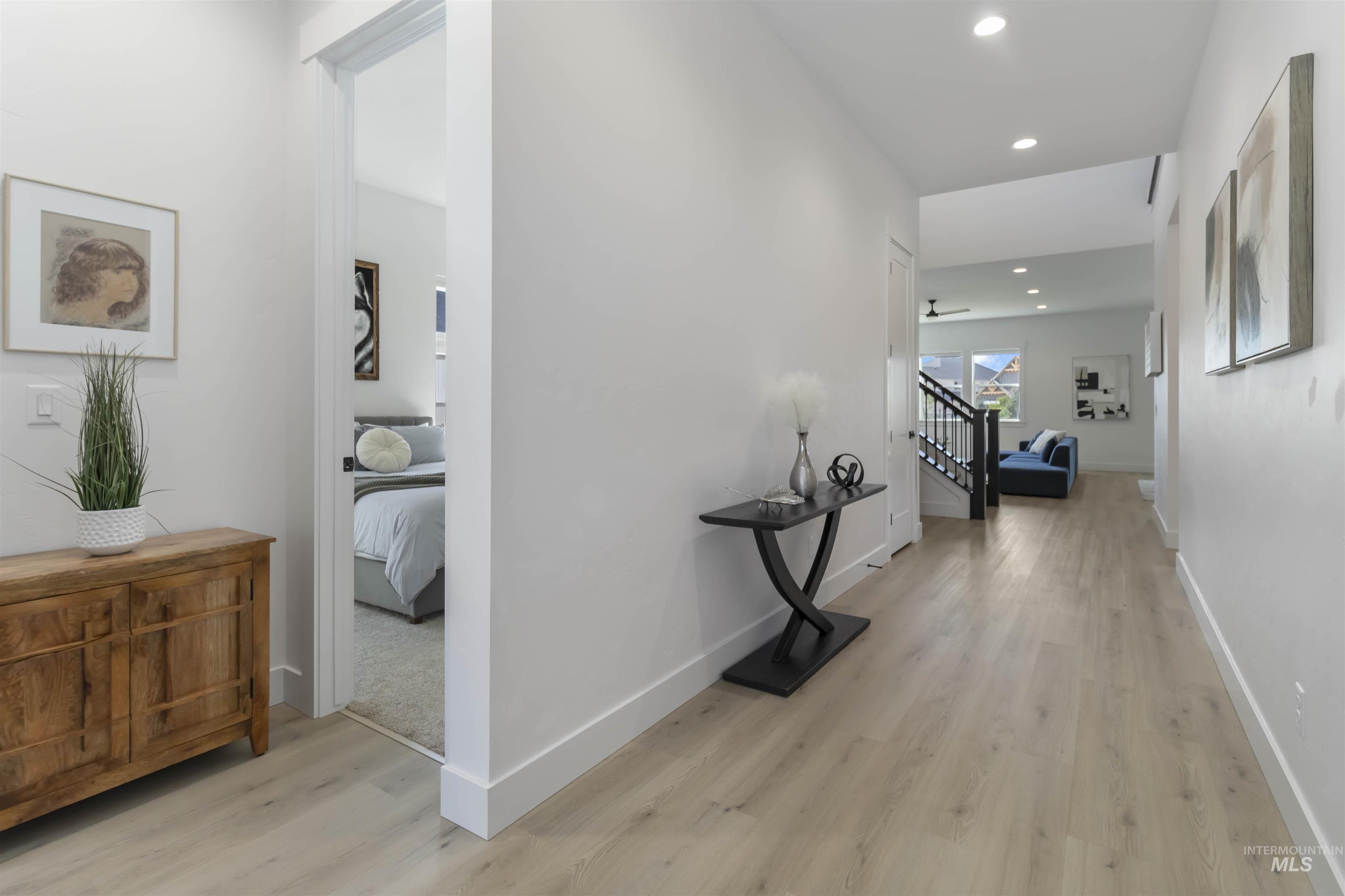 Hall with light wood-type flooring and recessed lighting