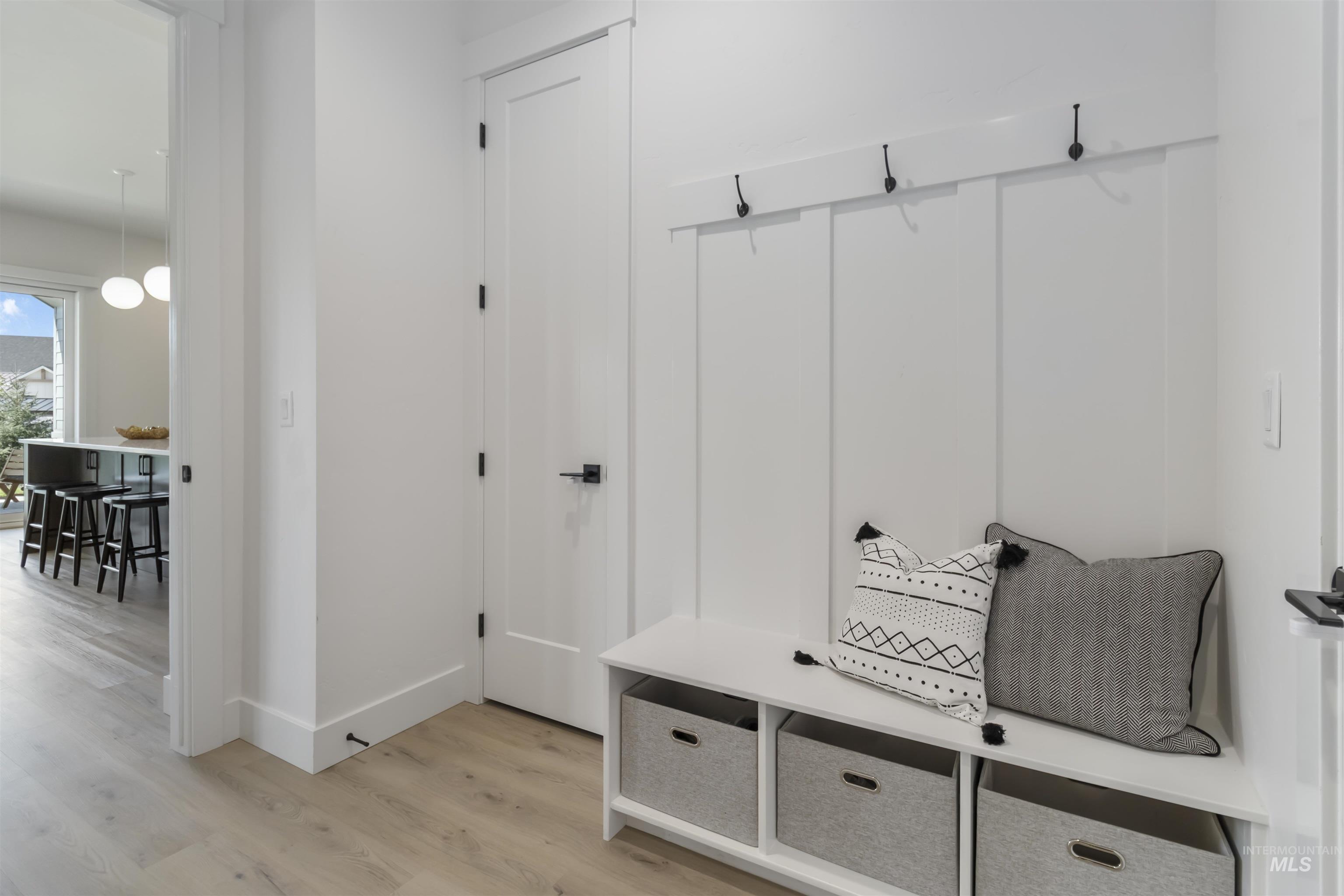 Mudroom featuring light wood-style floors and baseboards