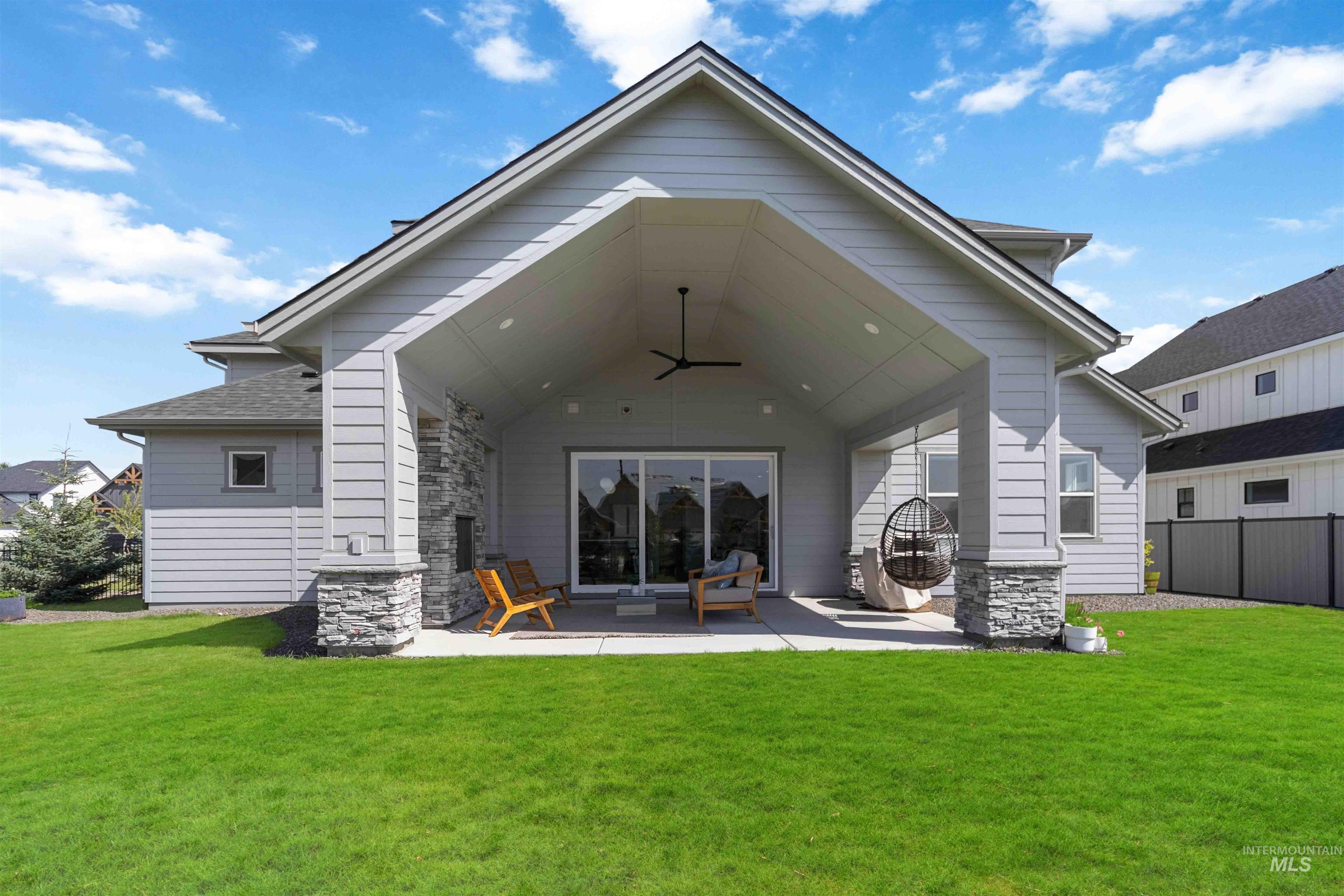 Rear view of property with a ceiling fan and a patio area