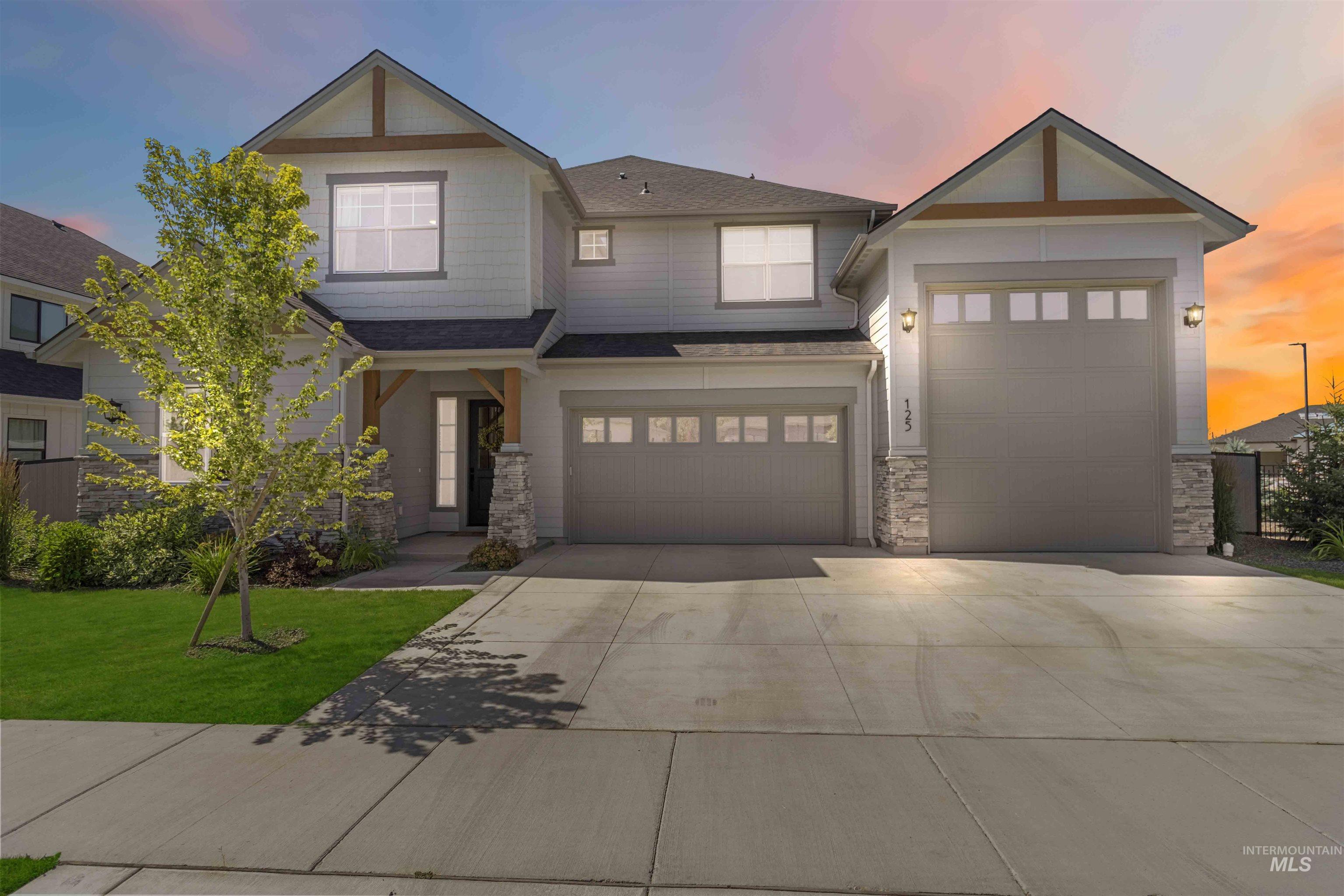 Craftsman inspired home featuring stone siding, concrete driveway, a front yard, a shingled roof, and an attached garage