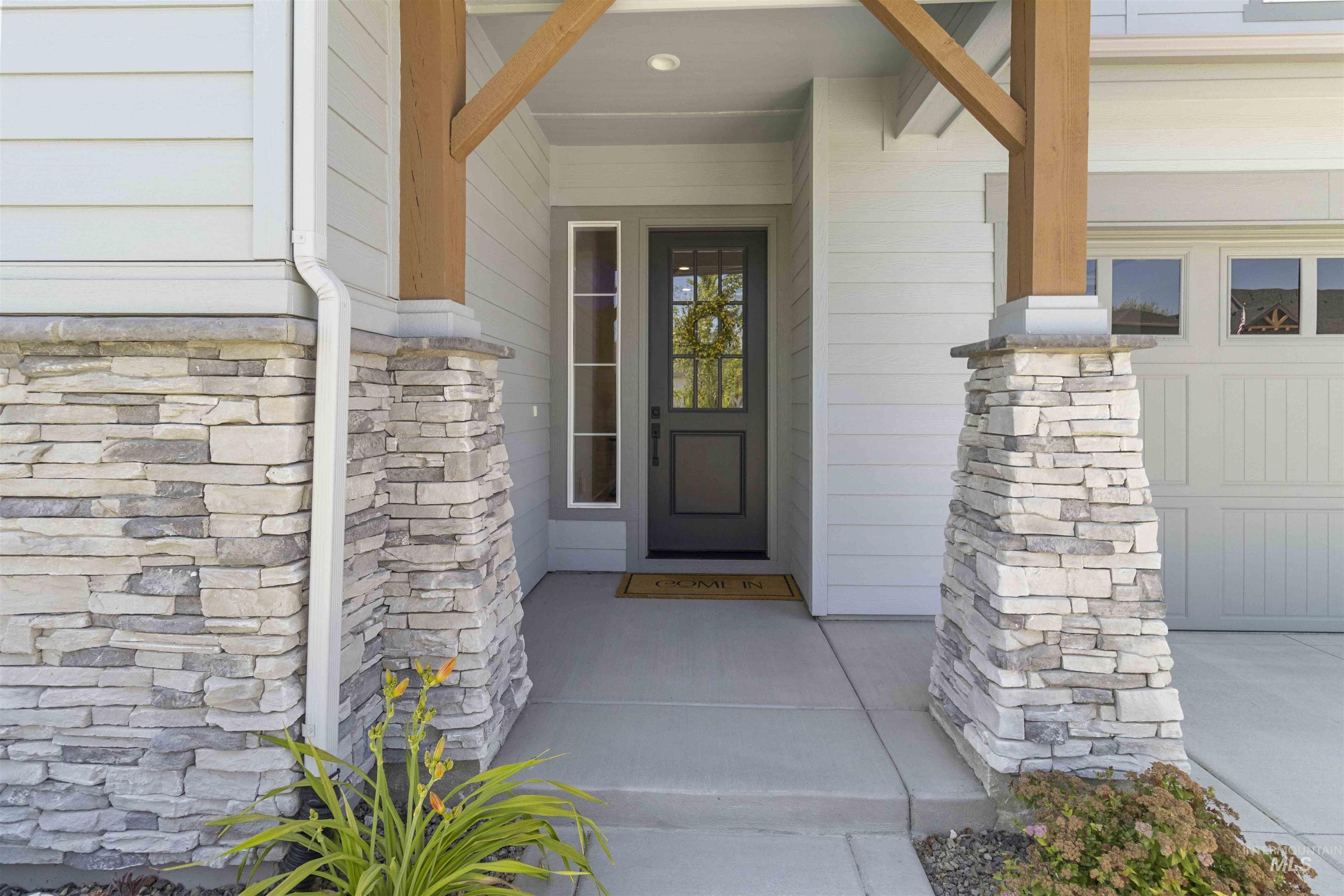 Entrance to property with stone siding and a porch