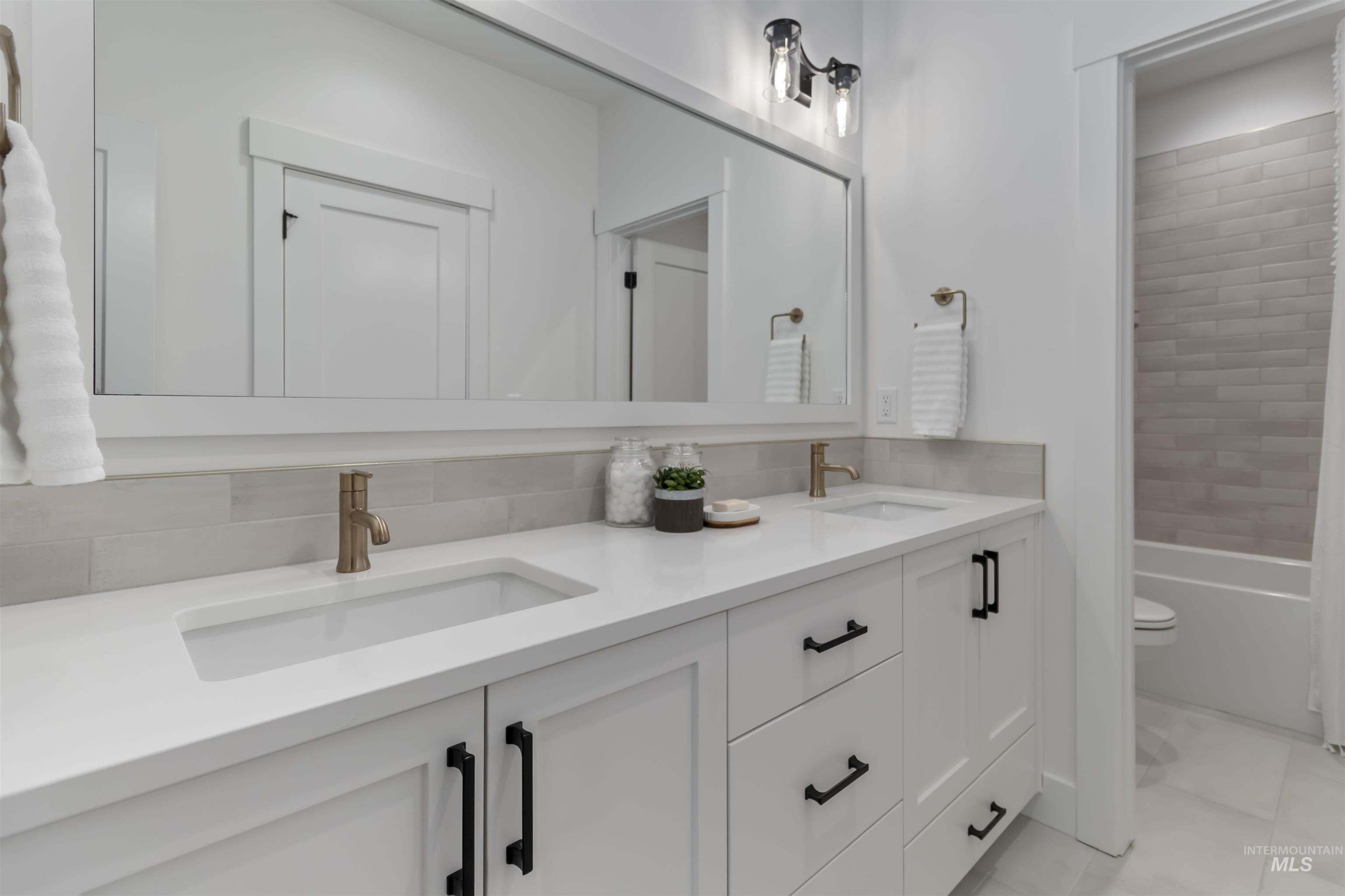 Full bathroom featuring double vanity and toilet