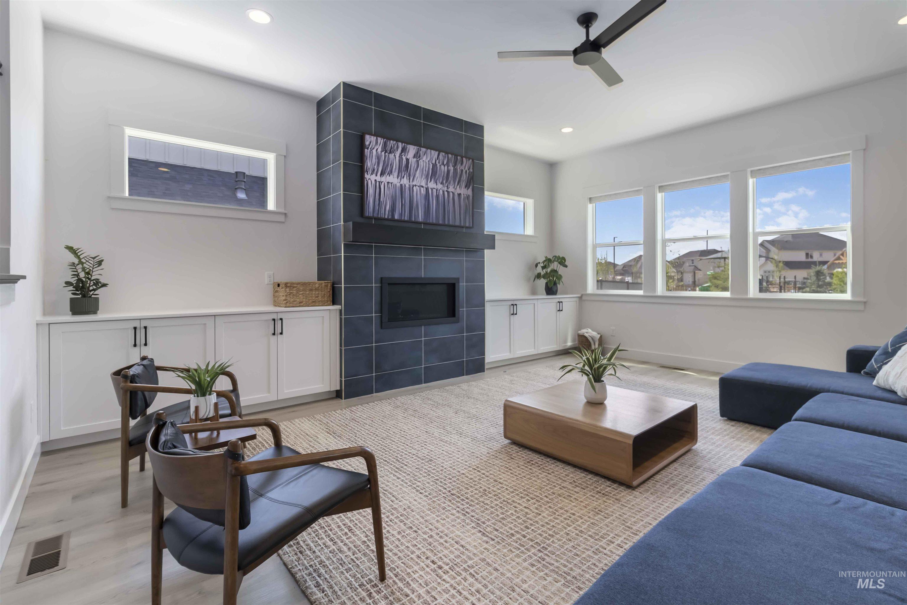Living area featuring a ceiling fan, recessed lighting, and a tile fireplace