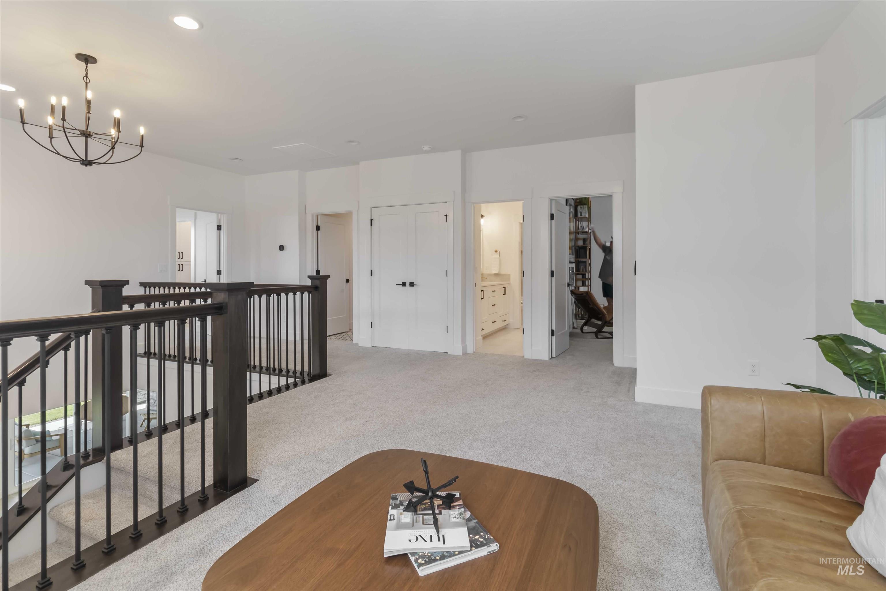 Living area with light carpet and a chandelier
