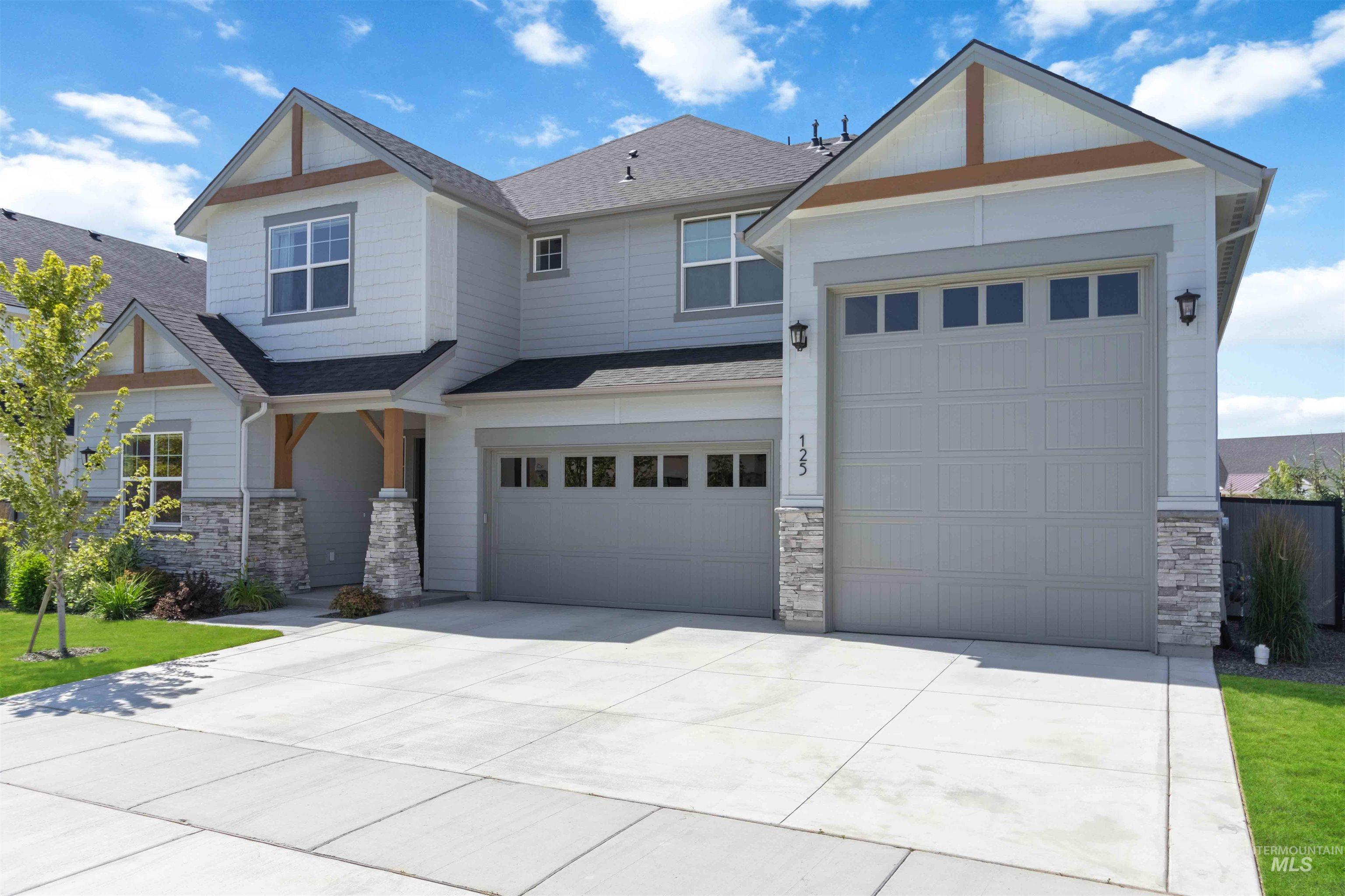 Craftsman inspired home with stone siding, roof with shingles, and driveway