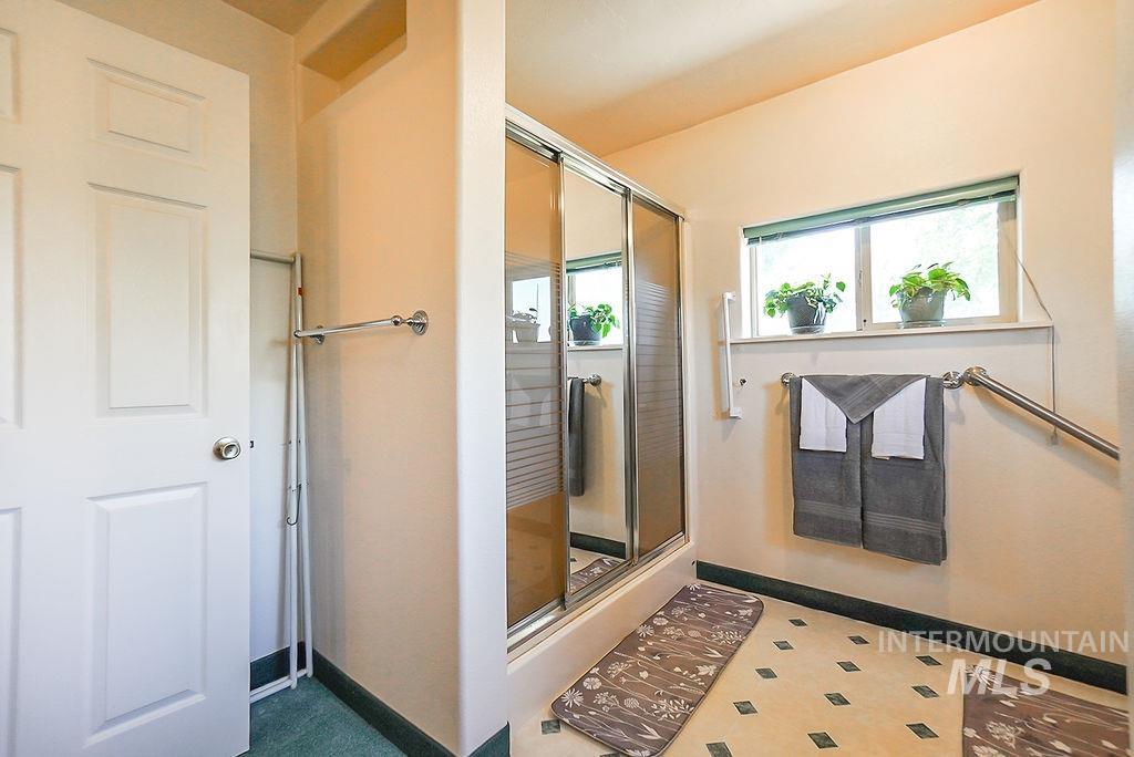 Full bathroom with a shower stall and baseboards