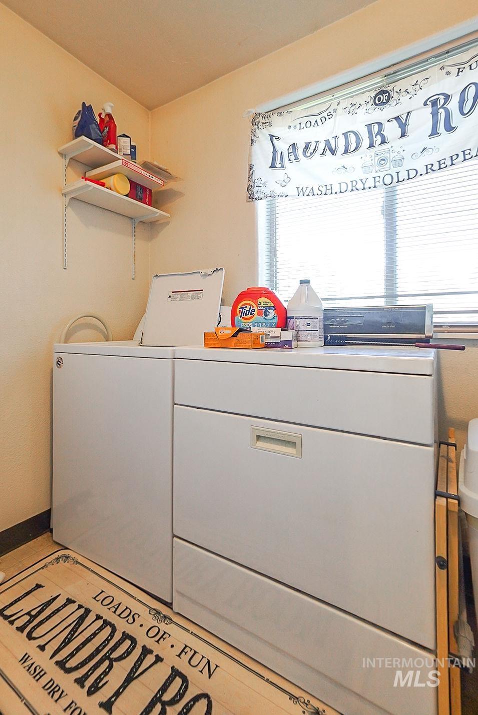 Washroom with separate washer and dryer and baseboards