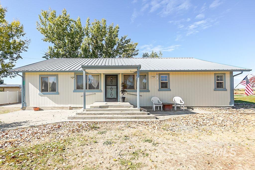 View of front of home featuring a metal roof and a patio