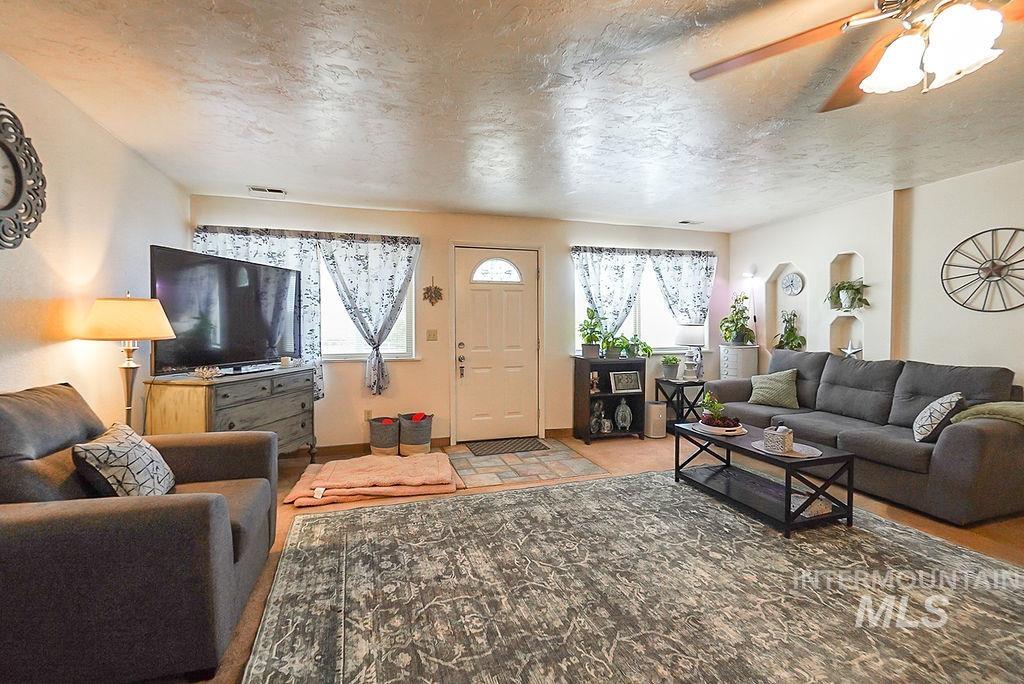 Living area with ceiling fan and a textured ceiling