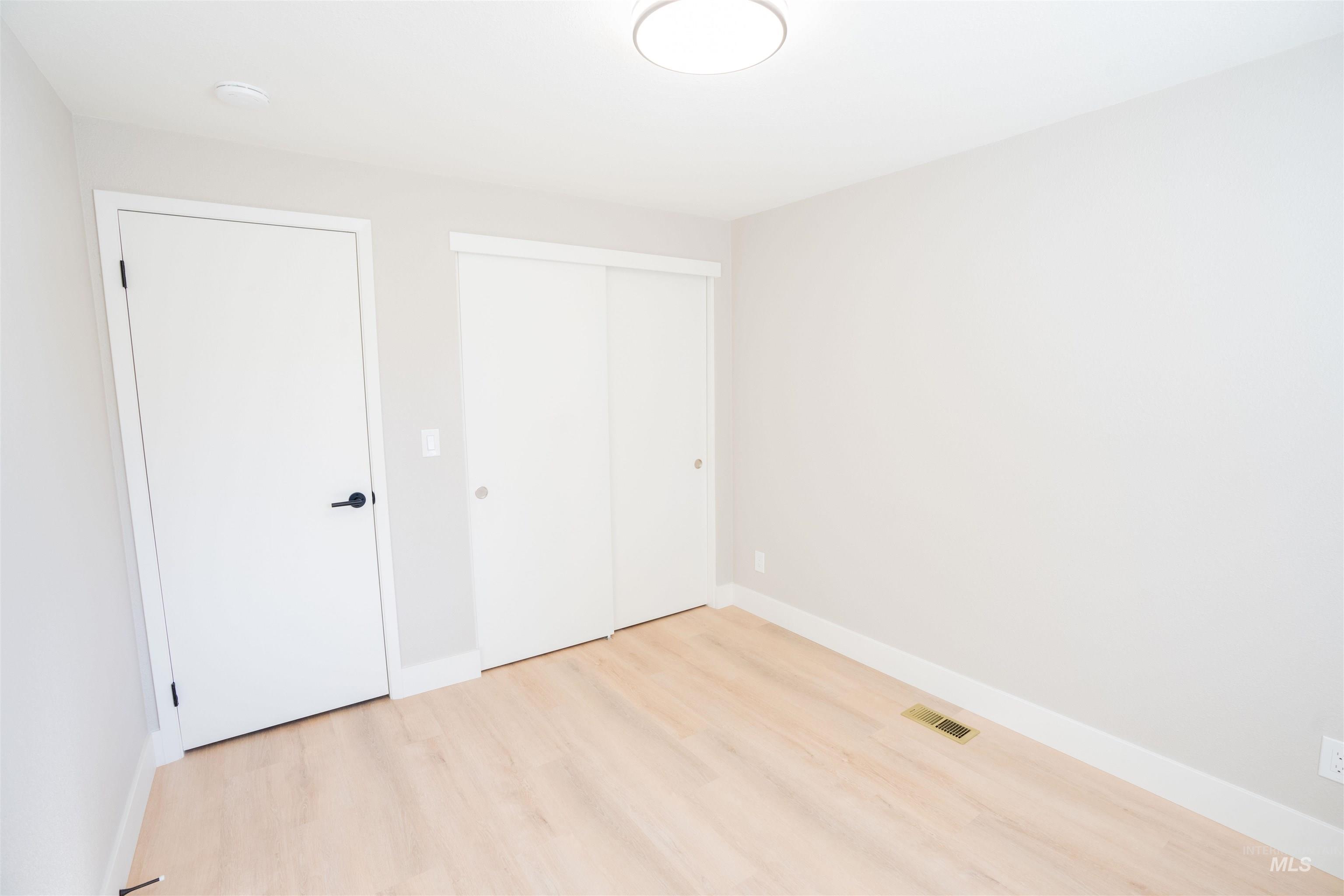 Unfurnished bedroom with light wood-type flooring and a closet