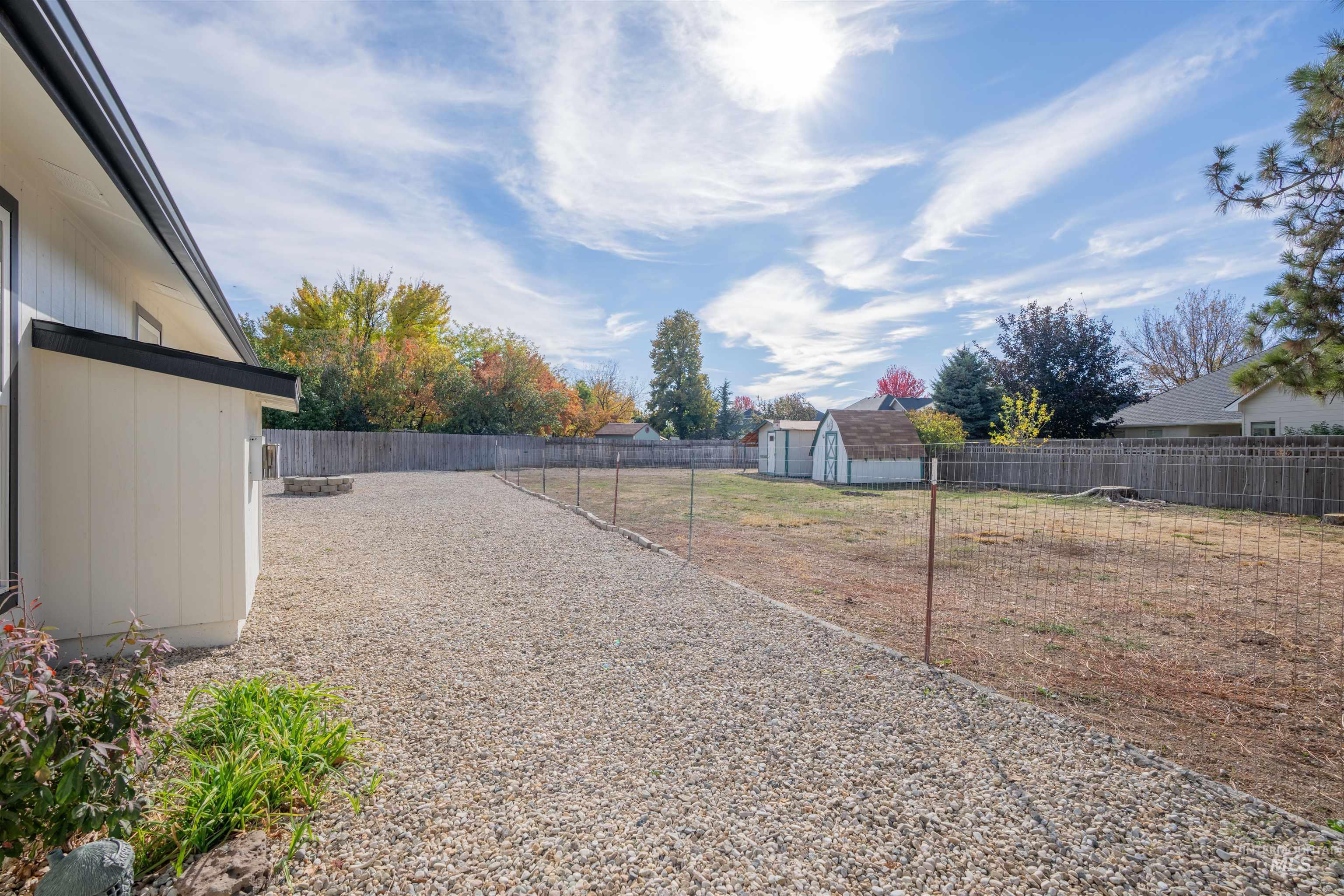 Fenced backyard featuring a storage unit