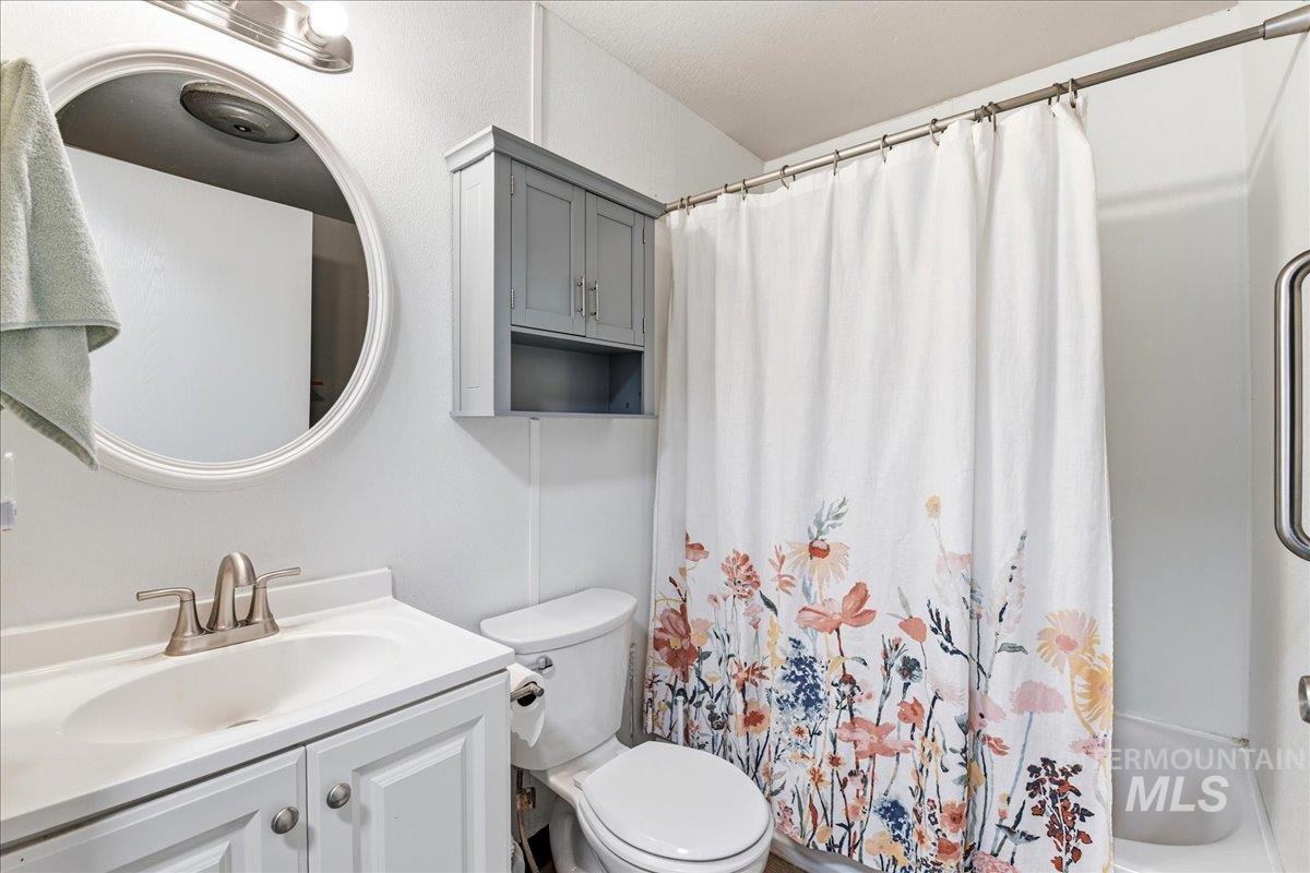 Bathroom featuring a white vanity with a single basin sink, brushed nickel faucet, and coordinating hardware