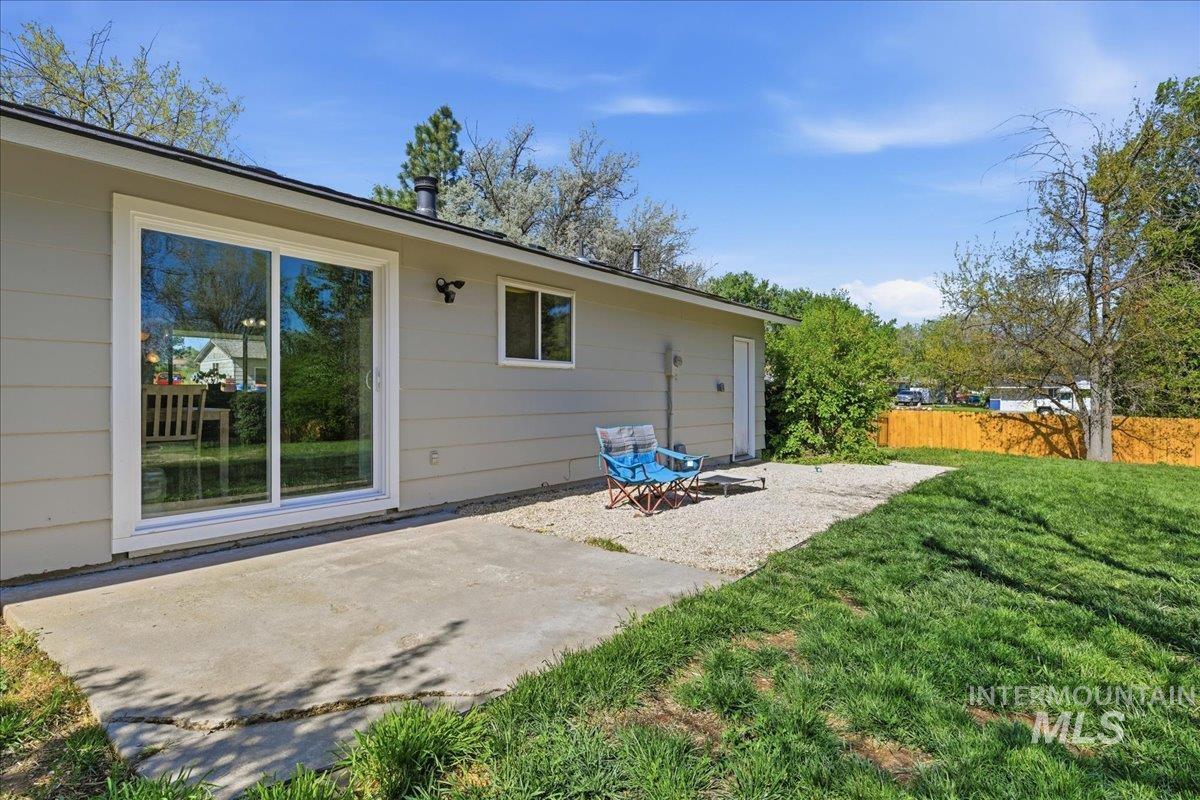 Rear exterior with a concrete patio and sliding glass door