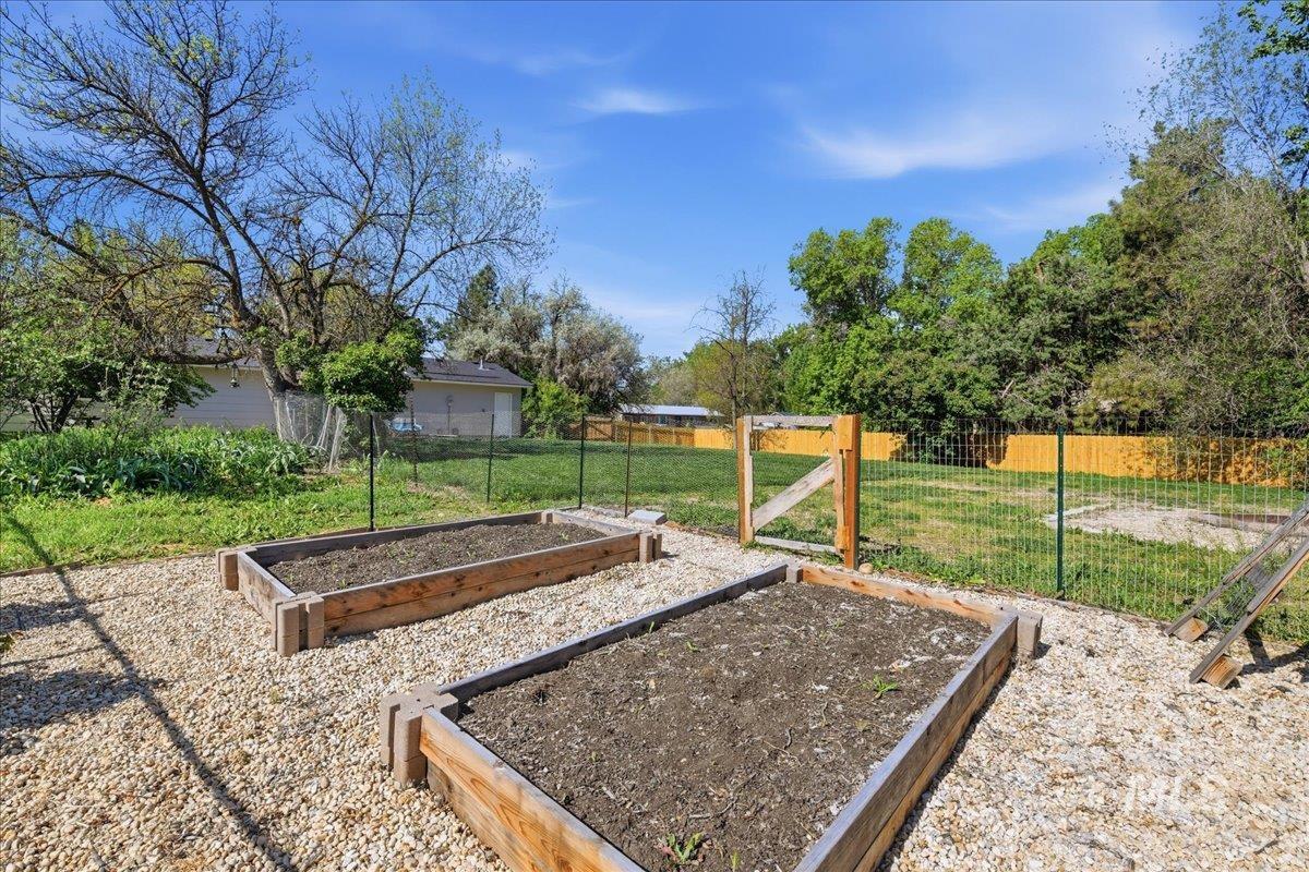 Gravel-covered garden area featuring two raised garden beds