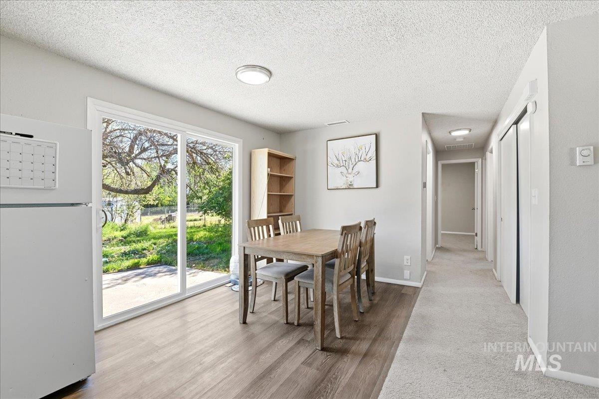 Dining area featuring wood-finish flooring, a sliding glass door to the exterior, and a built-in recessed ceiling light