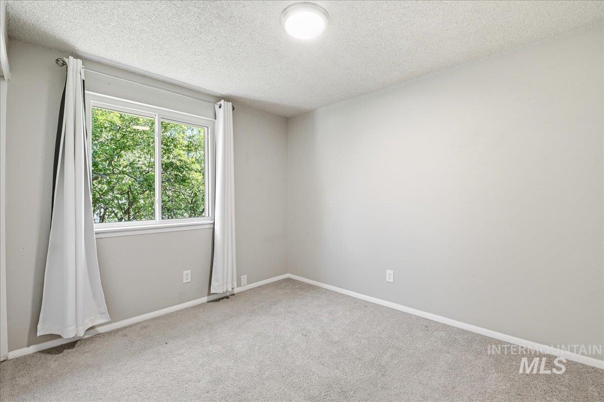 Bedroom featuring a large double window, light gray carpeting, and a flush-mount ceiling light