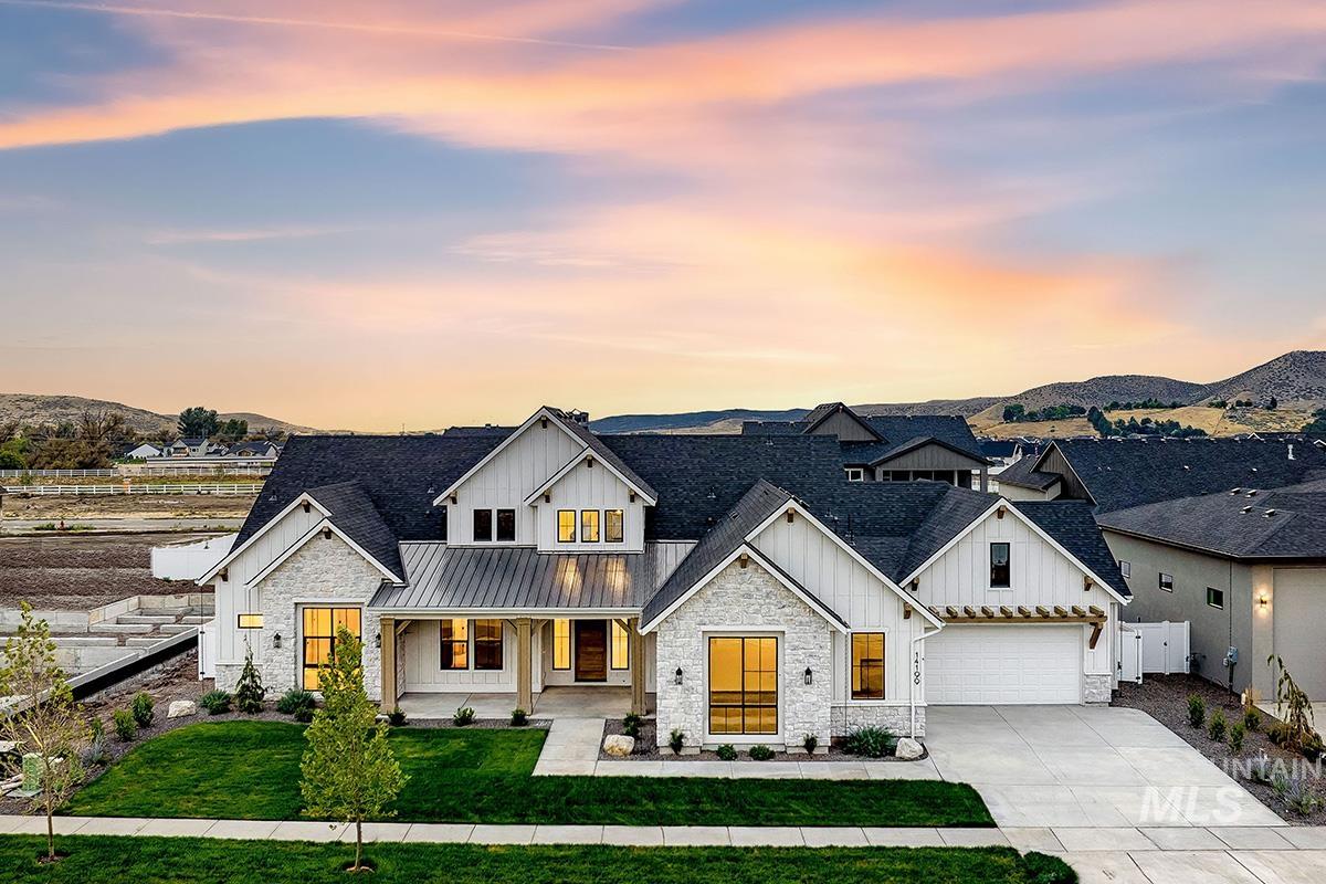 Modern inspired farmhouse with board and batten siding, stone siding, concrete driveway, and a porch