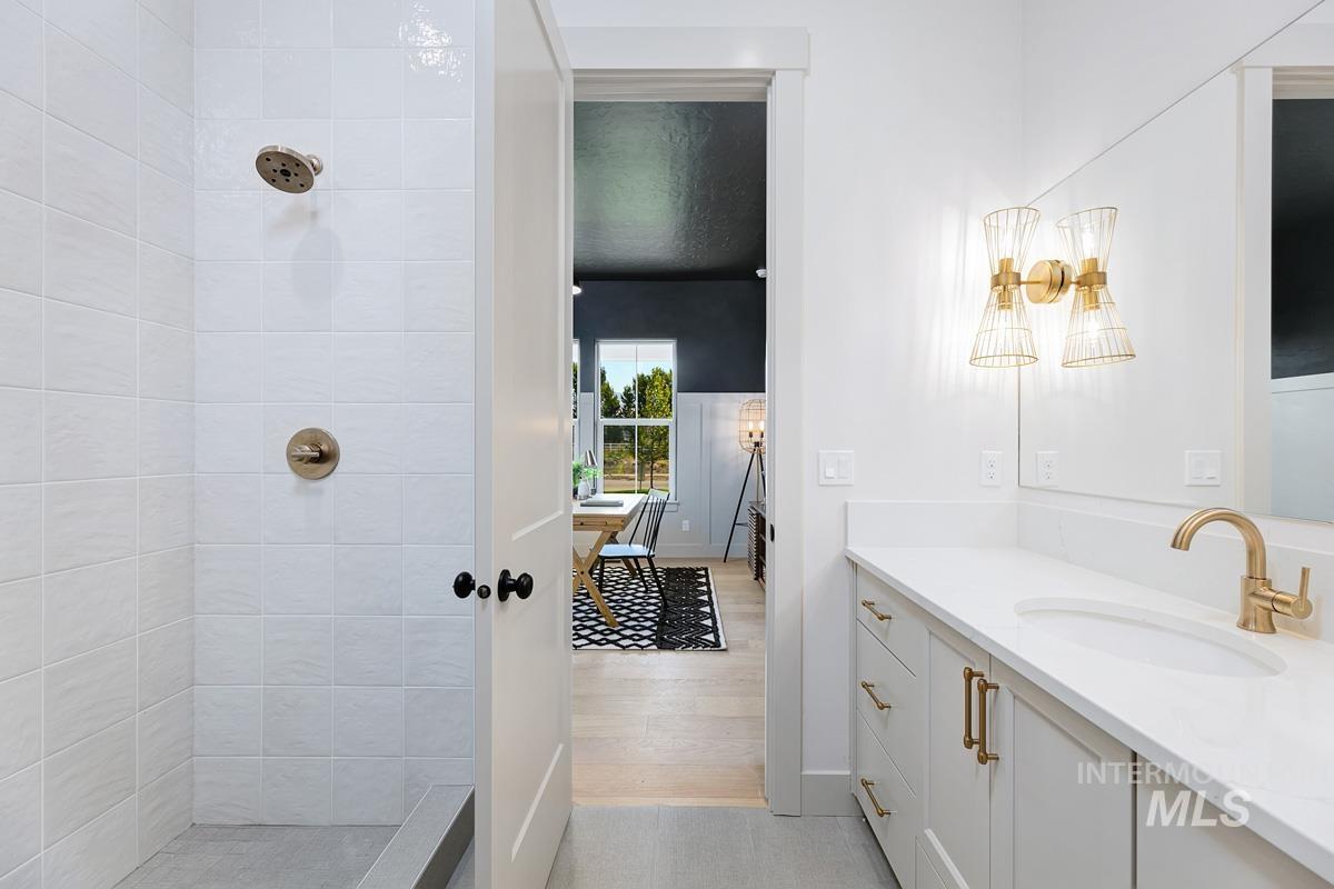 Full bathroom featuring tiled shower and vanity