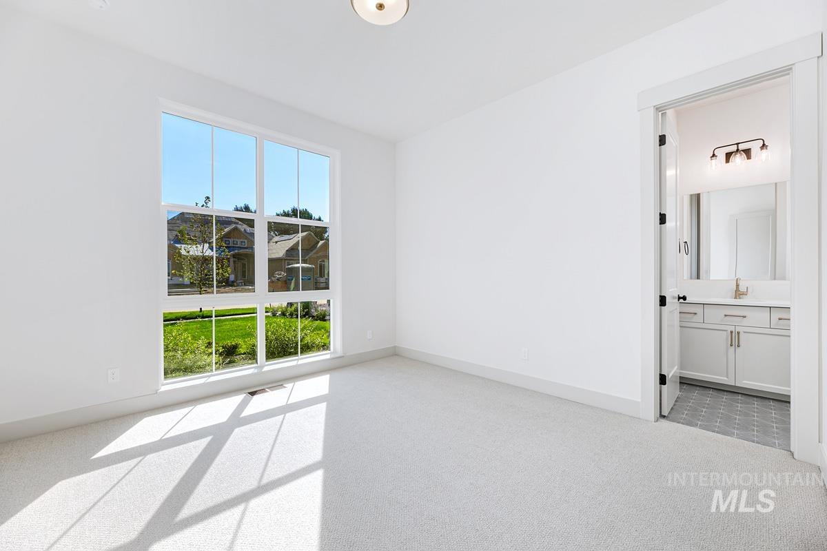 Unfurnished bedroom featuring light carpet and connected bathroom