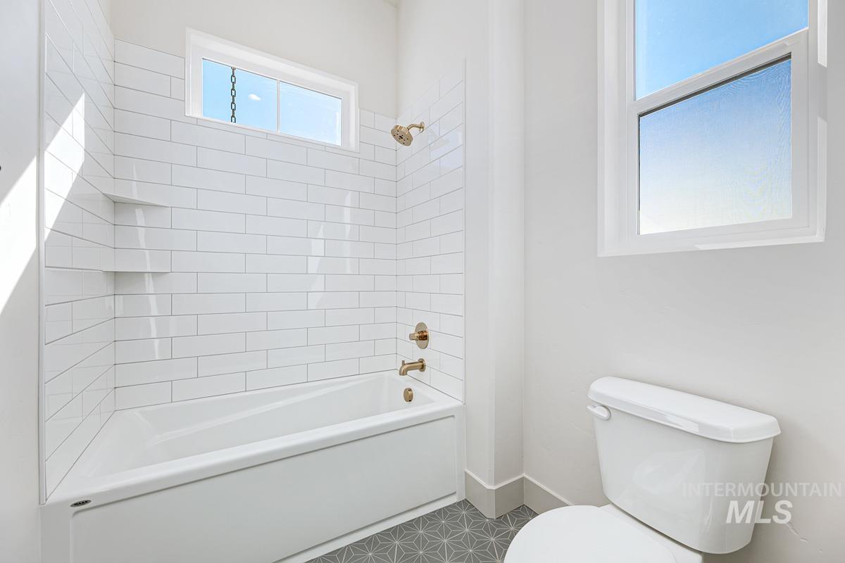 Bathroom with shower / bathtub combination and tile patterned flooring