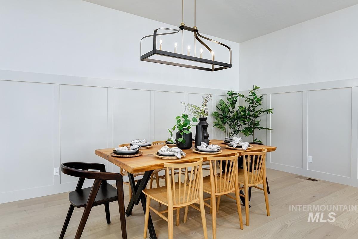 Dining room featuring a decorative wall and light wood-style floors