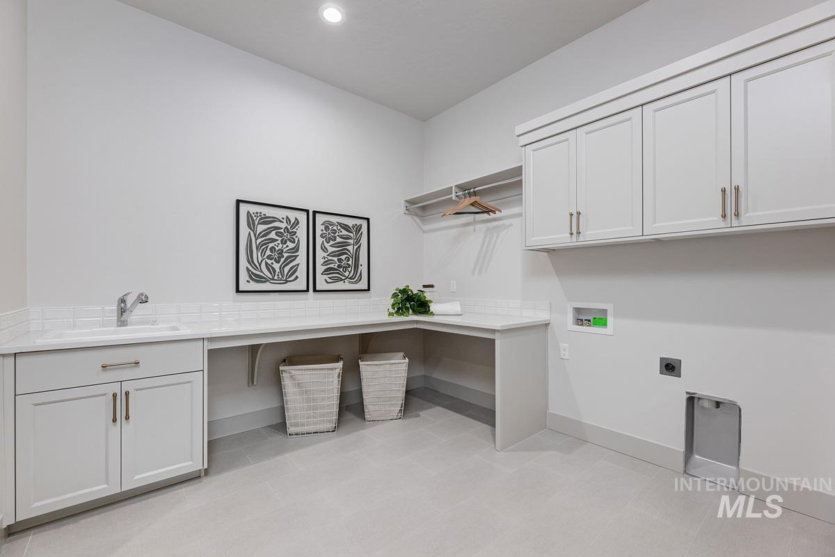 Laundry area featuring hookup for a washing machine, cabinet space, recessed lighting, hookup for an electric dryer, and light tile patterned floors