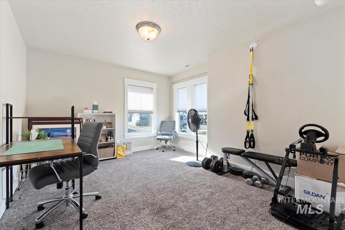 Carpeted office space featuring baseboards