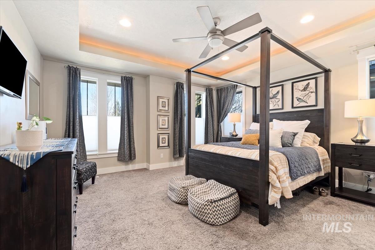 Bedroom with light colored carpet, ceiling fan, and recessed lighting