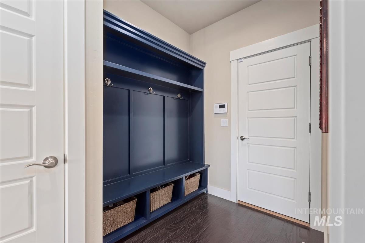 Mudroom featuring dark wood-style floors and baseboards