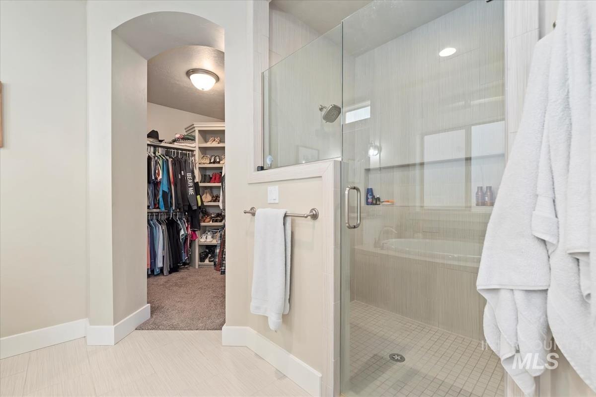 Bathroom with a spacious closet and a stall shower