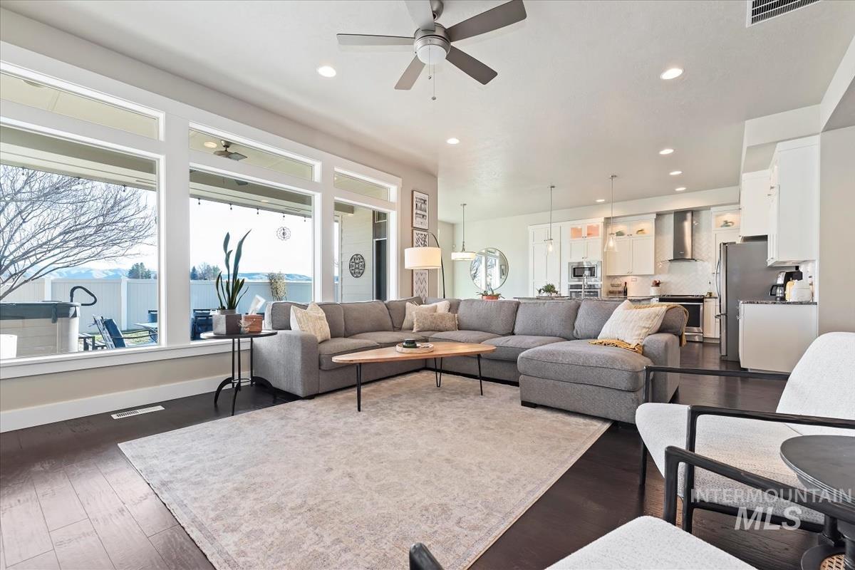 Living area with dark wood-style flooring, recessed lighting, and a ceiling fan