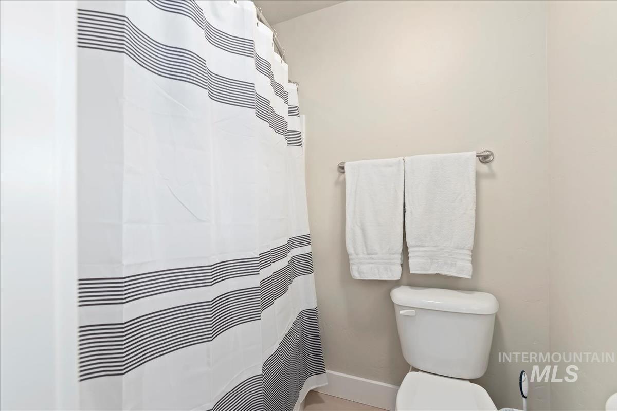 Full bathroom with curtained shower and toilet