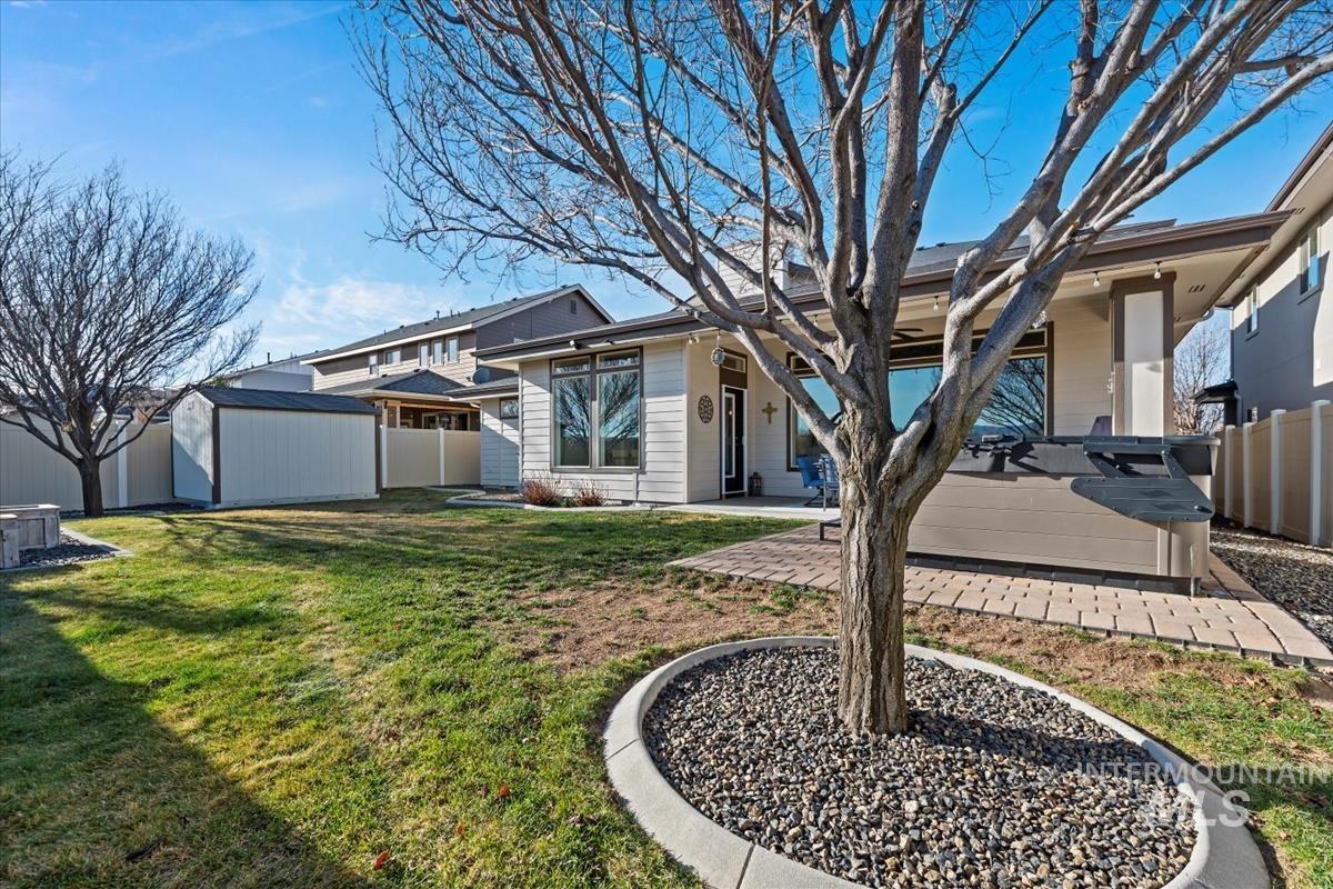 Rear view of property featuring a fenced backyard, a storage unit, and a patio area