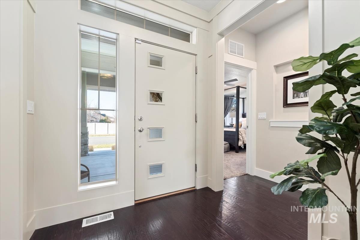 Entrance foyer with dark wood-style flooring and baseboards