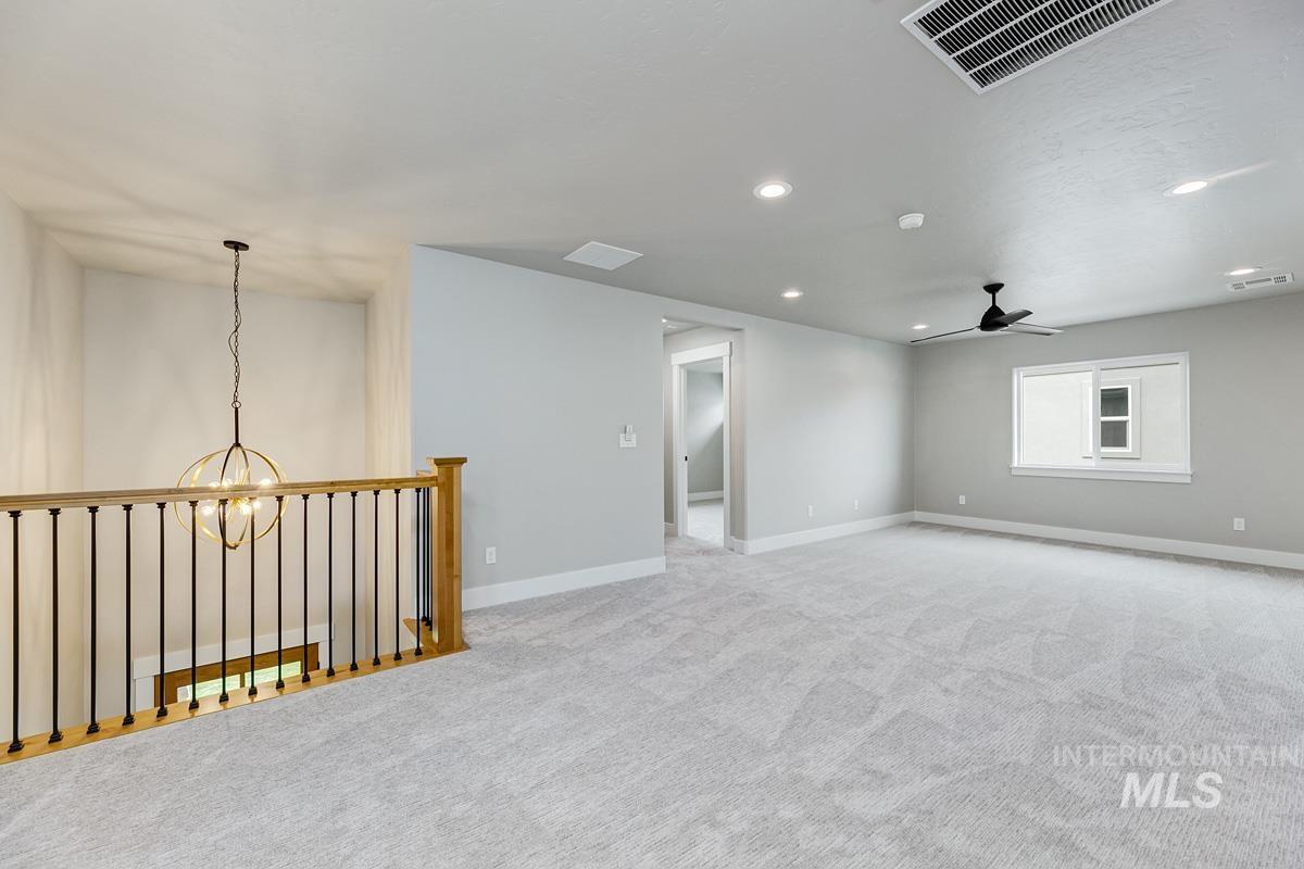 Empty room with recessed lighting, a chandelier, light colored carpet, and ceiling fan