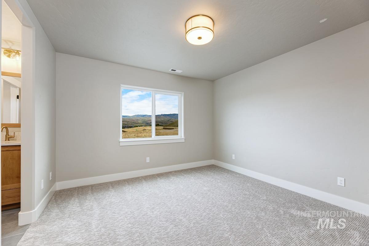 Unfurnished room with baseboards and light carpet