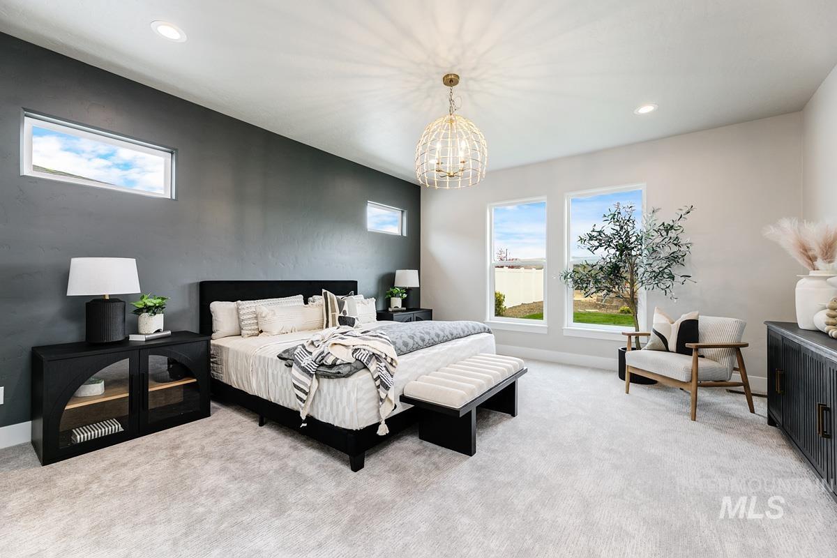 Bedroom featuring multiple windows, light colored carpet, a chandelier, and recessed lighting