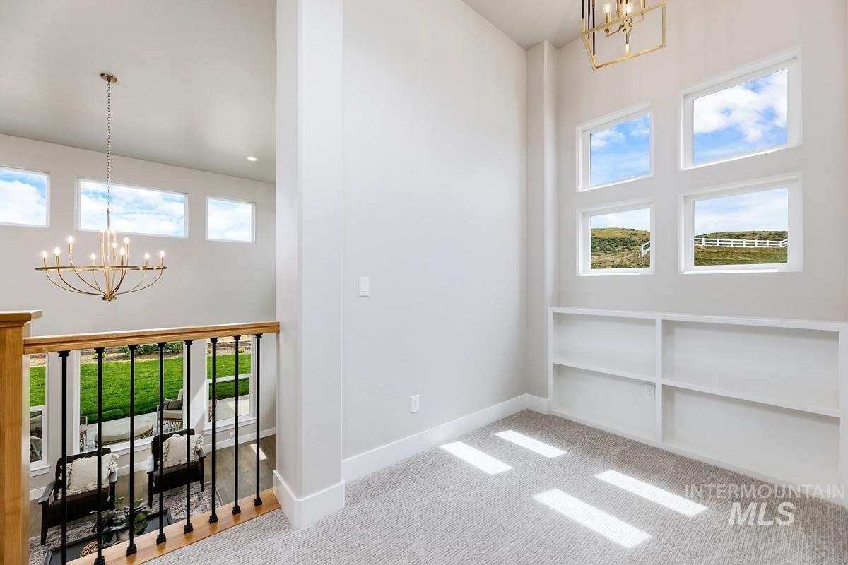 Interior space featuring a chandelier, healthy amount of natural light, and a high ceiling