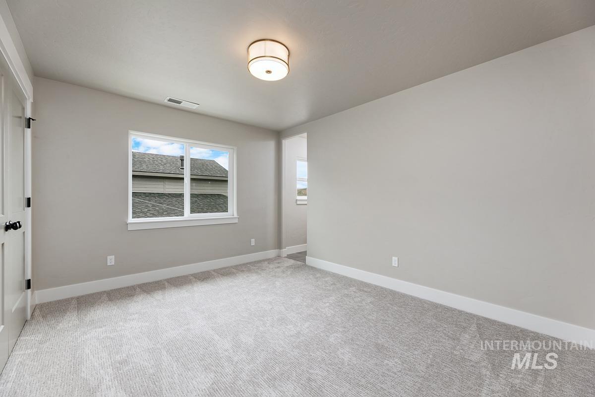 Empty room with baseboards and light carpet