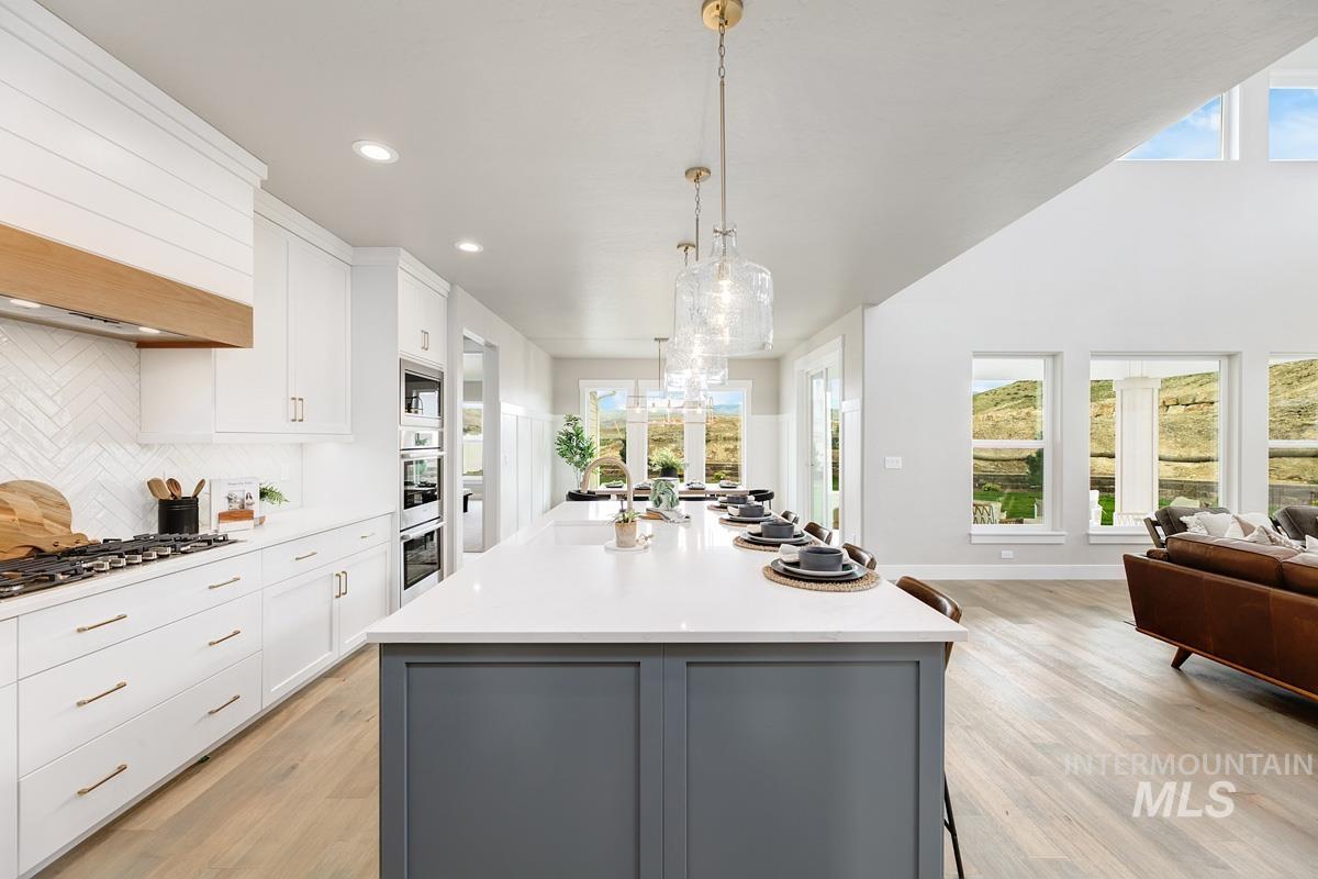 Kitchen with white cabinetry, gray cabinetry, decorative light fixtures, light wood-style flooring, and recessed lighting