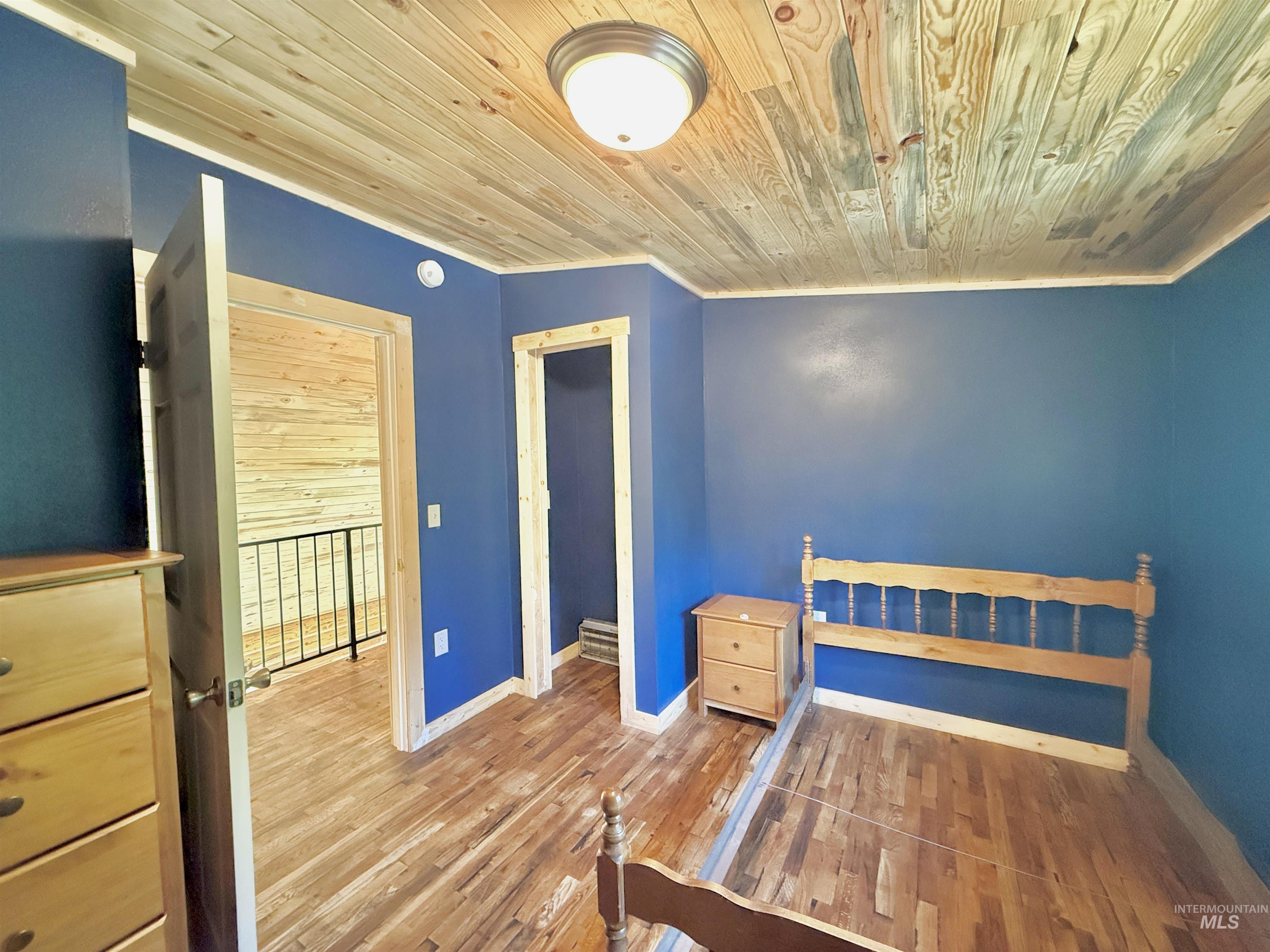Unfurnished bedroom featuring wooden ceiling and wood finished floors