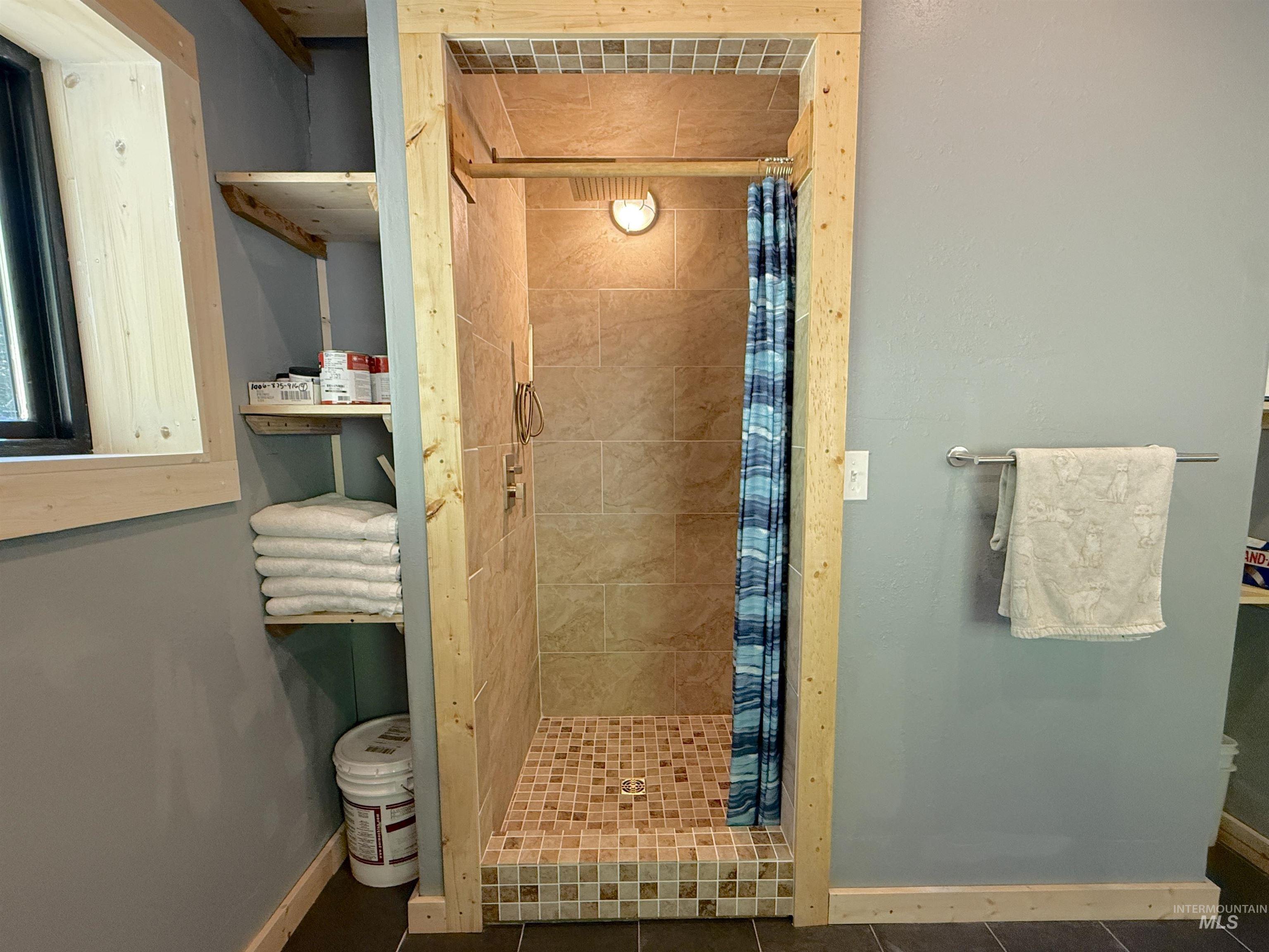 Full bath with a stall shower and tile patterned floors