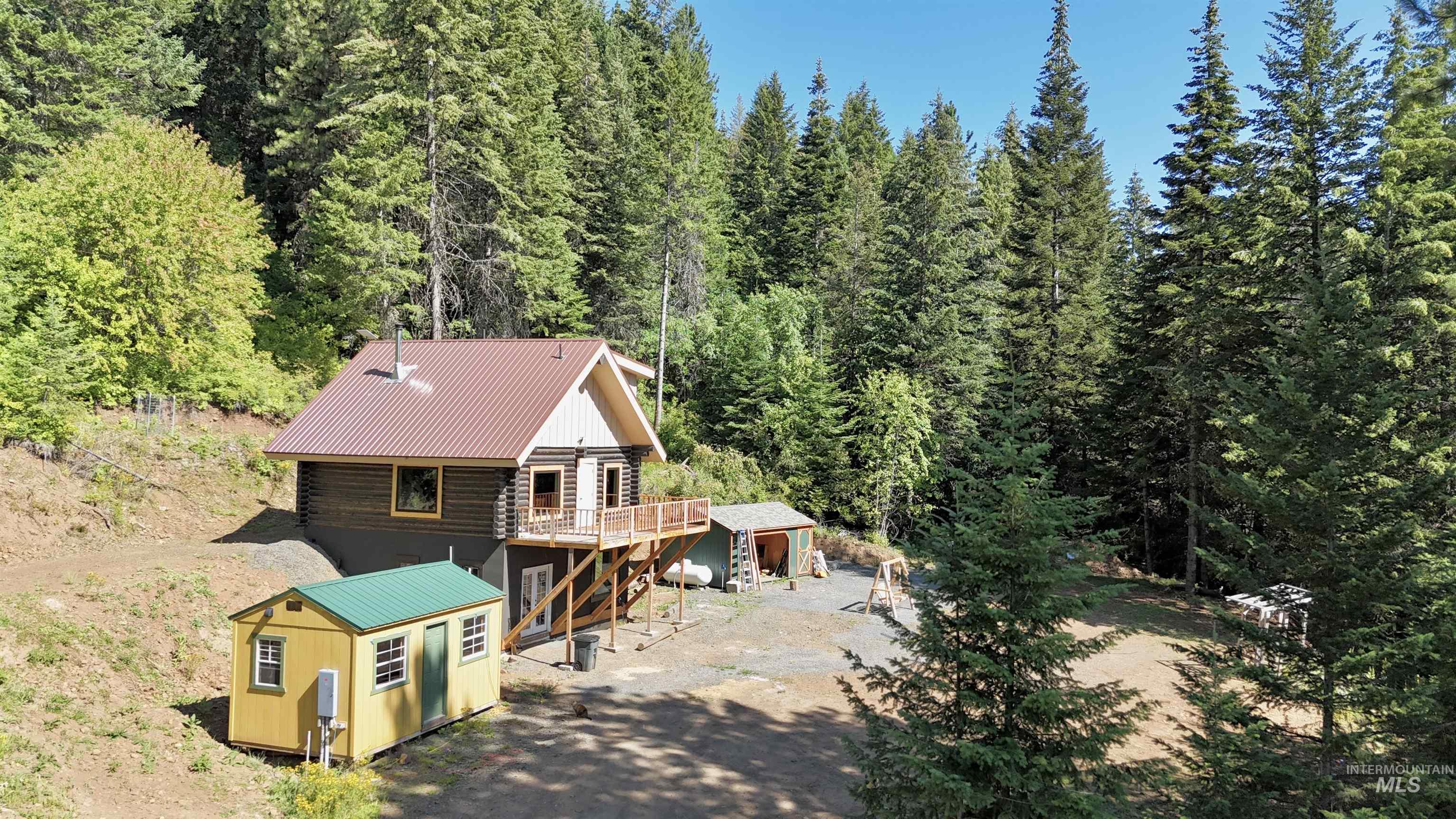 Aerial view of property and surrounding area with a heavily wooded area