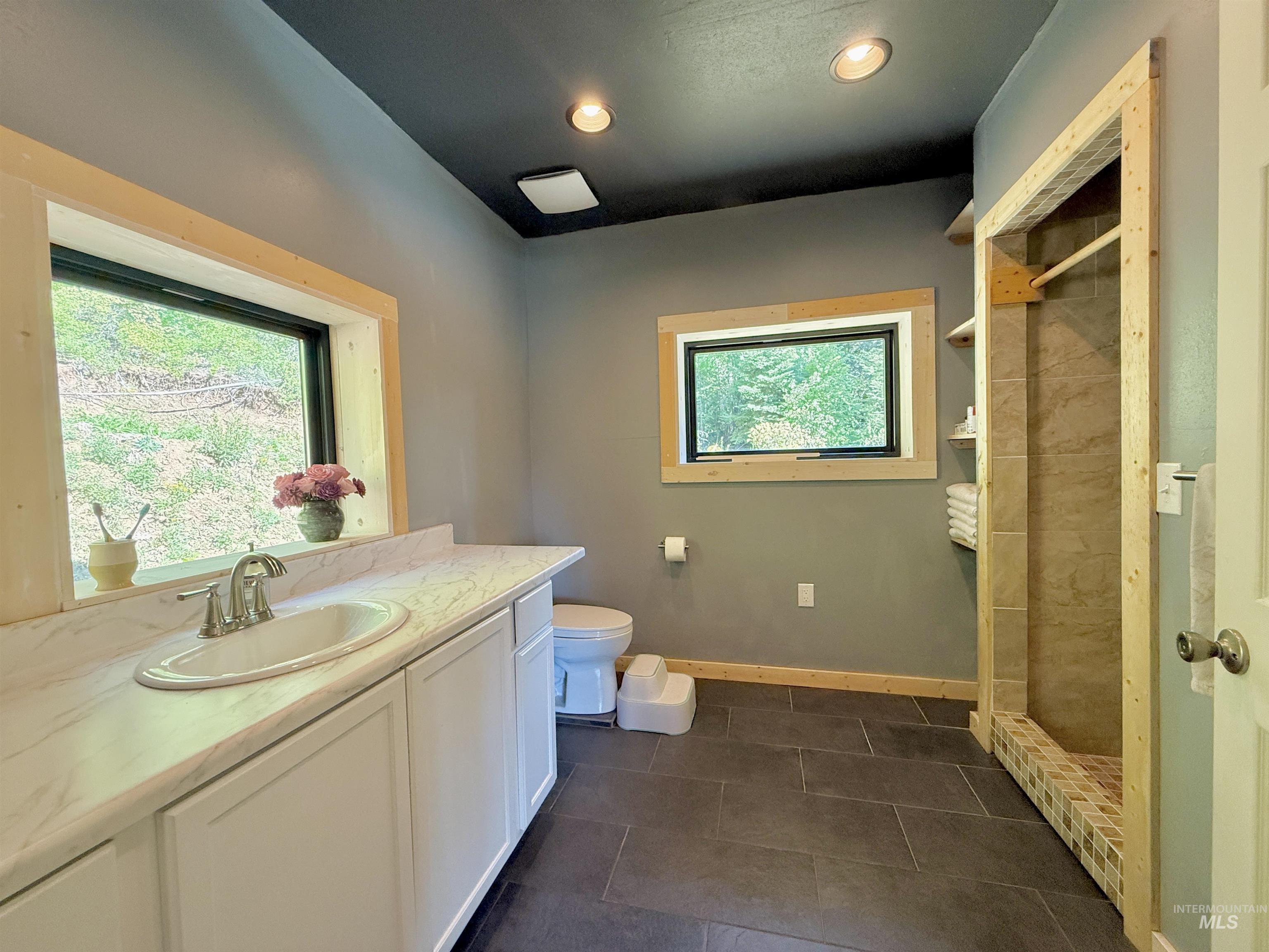Bathroom with a stall shower, vanity, recessed lighting, and tile patterned floors