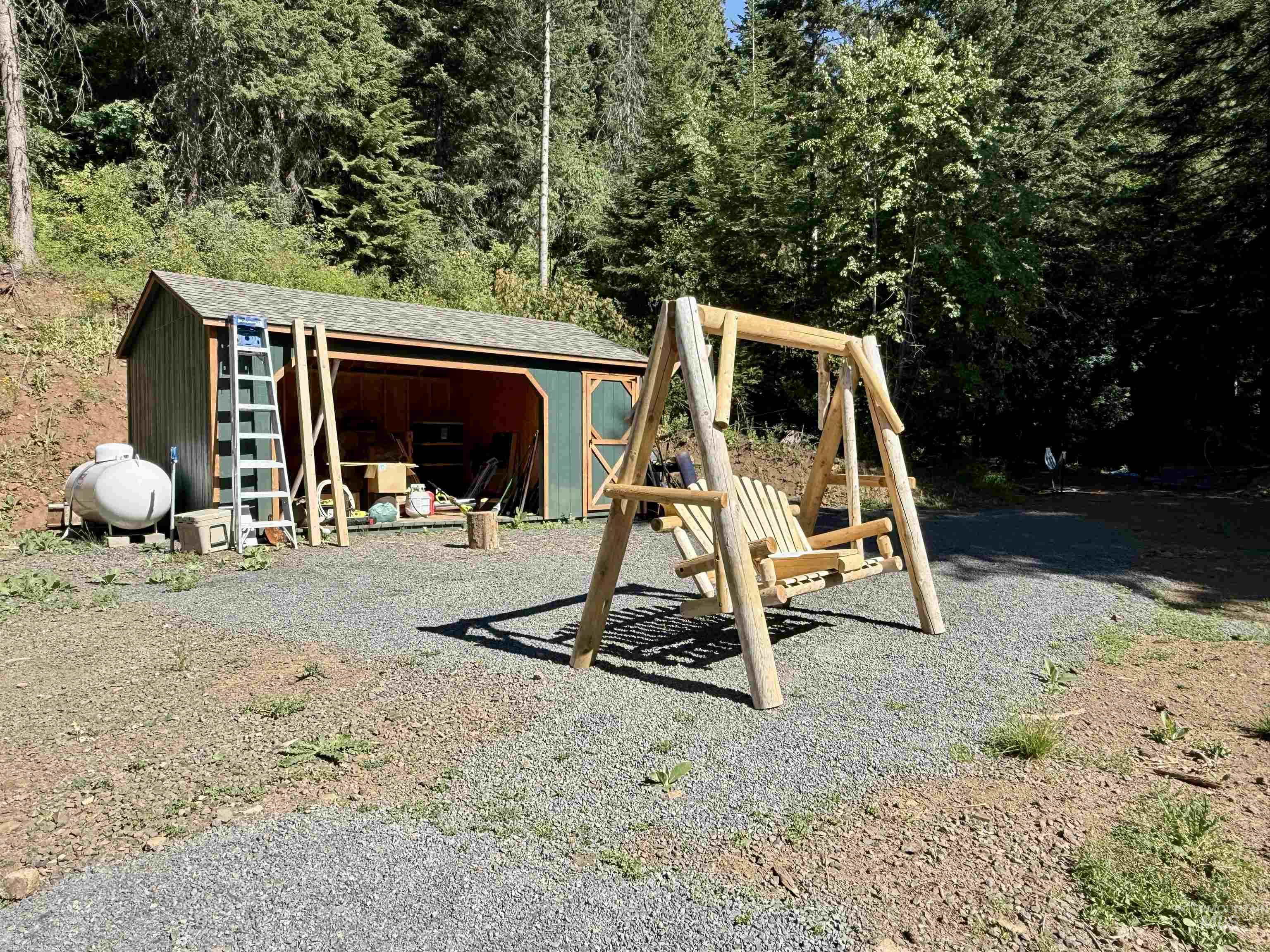 View of playground with a storage unit and a forest view