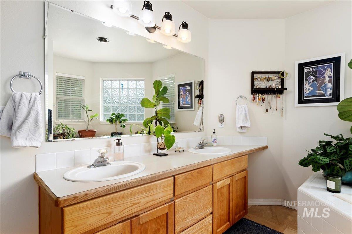Bathroom featuring double vanity and a bath