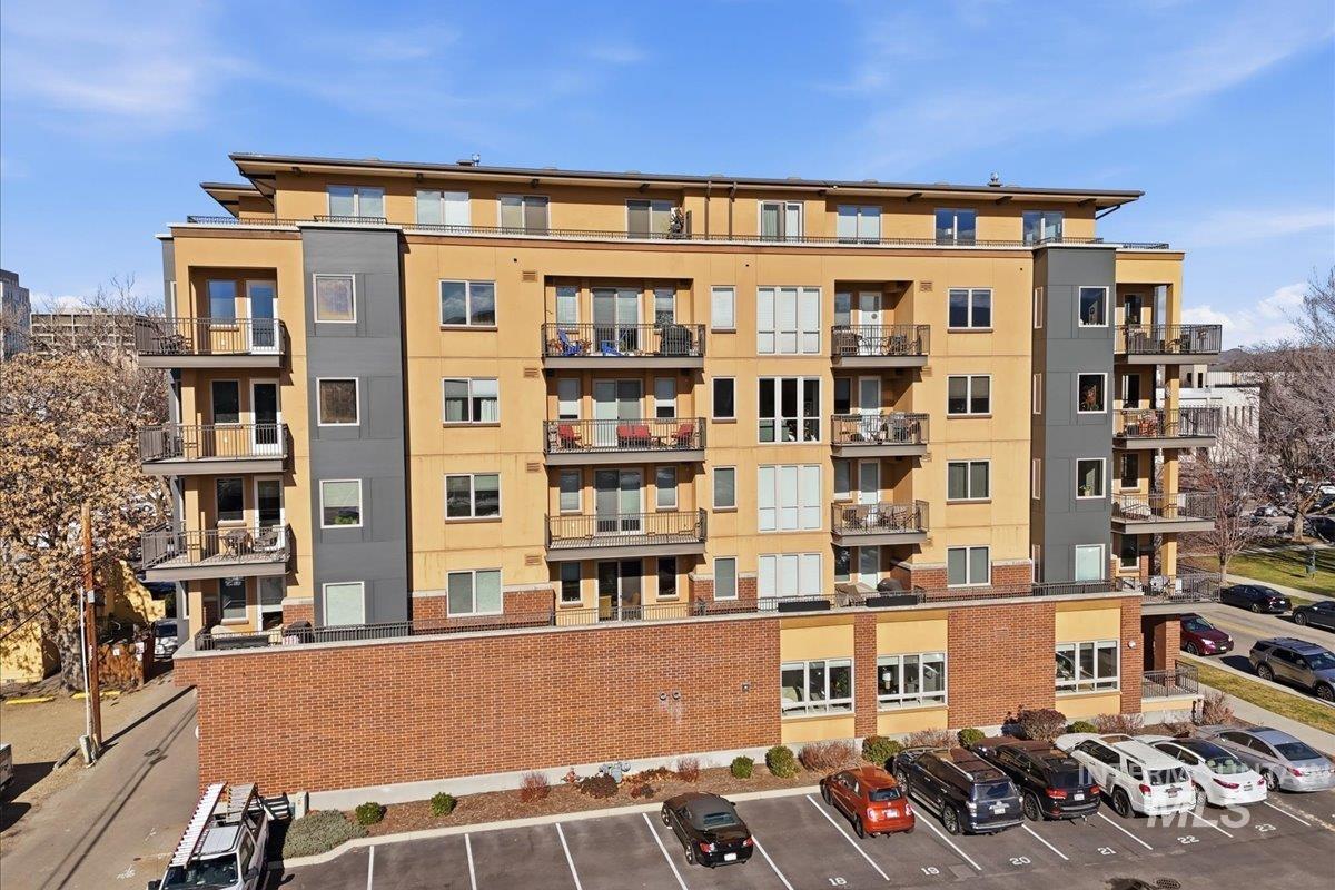 View of apartment building / complex with uncovered parking