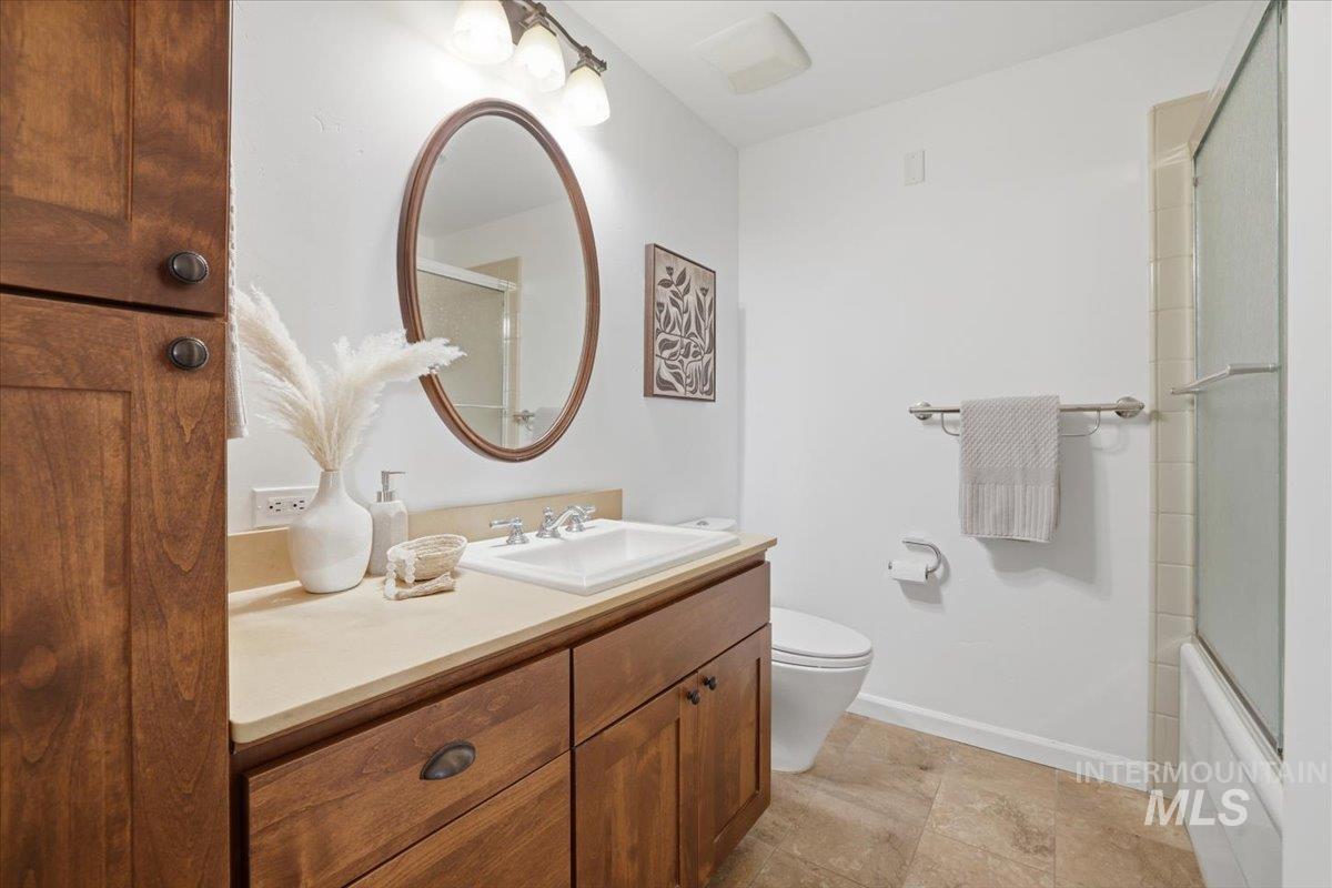 Full bathroom featuring vanity and bath / shower combo with glass door