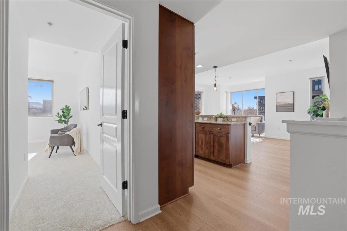 Hall featuring light wood-style flooring and baseboards