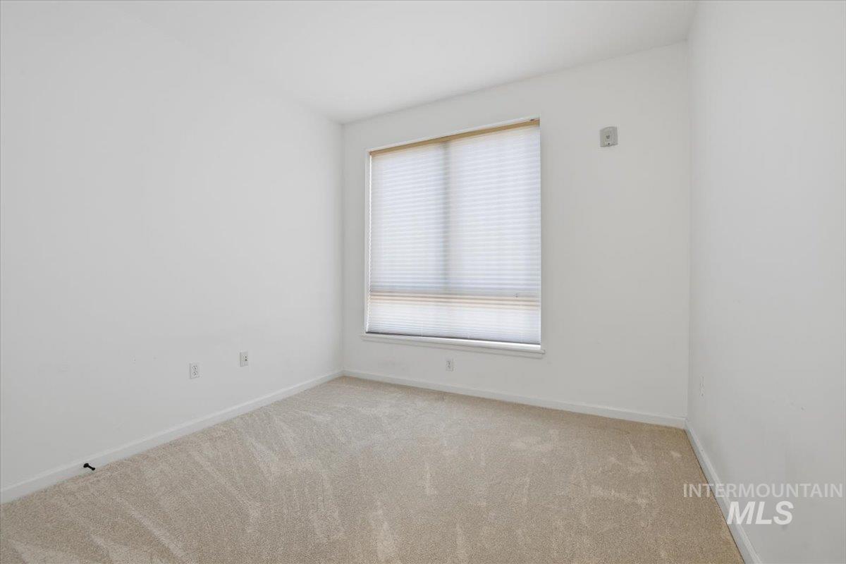 Spare room with baseboards and light carpet
